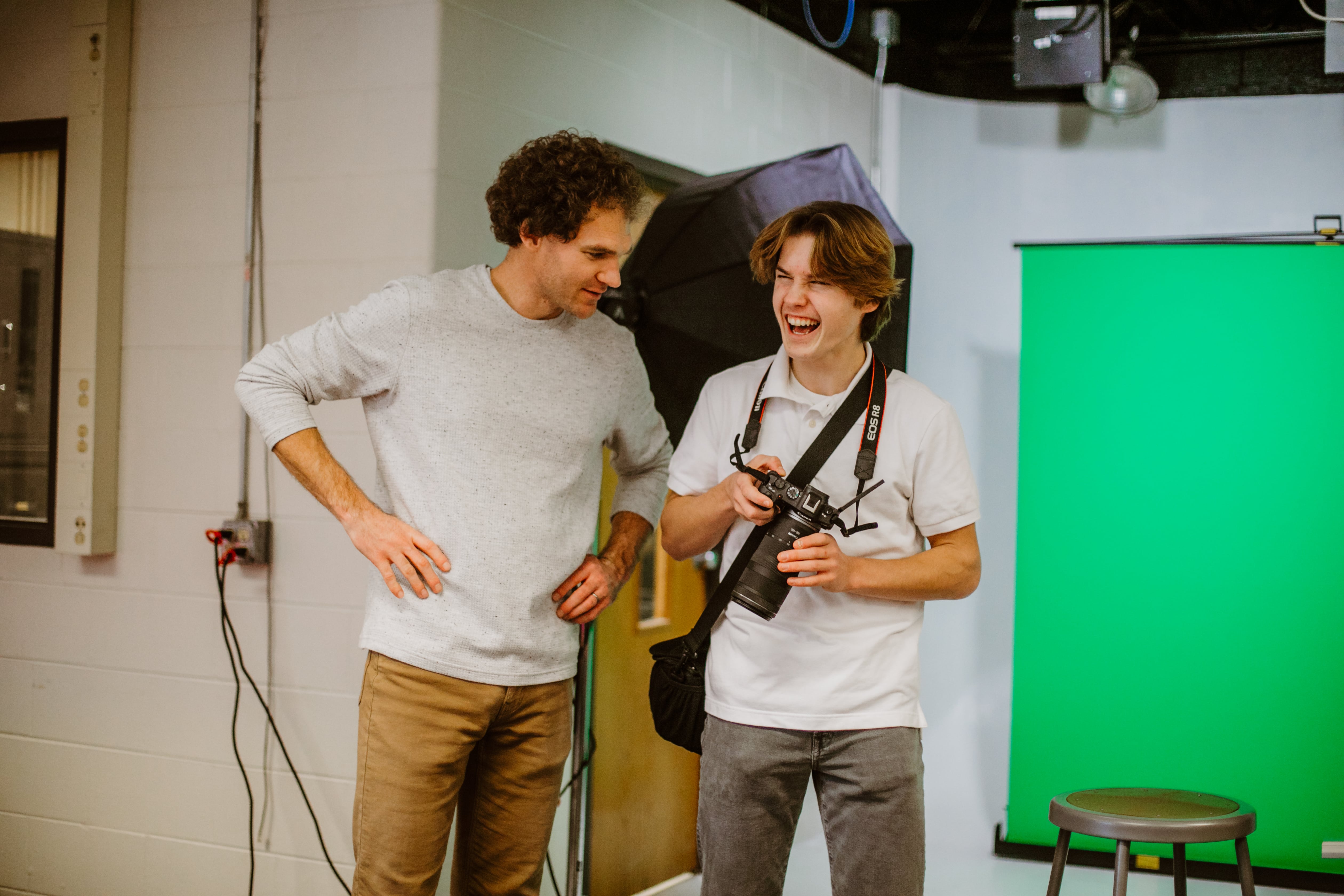 teacher and studentg laughing in hallway 