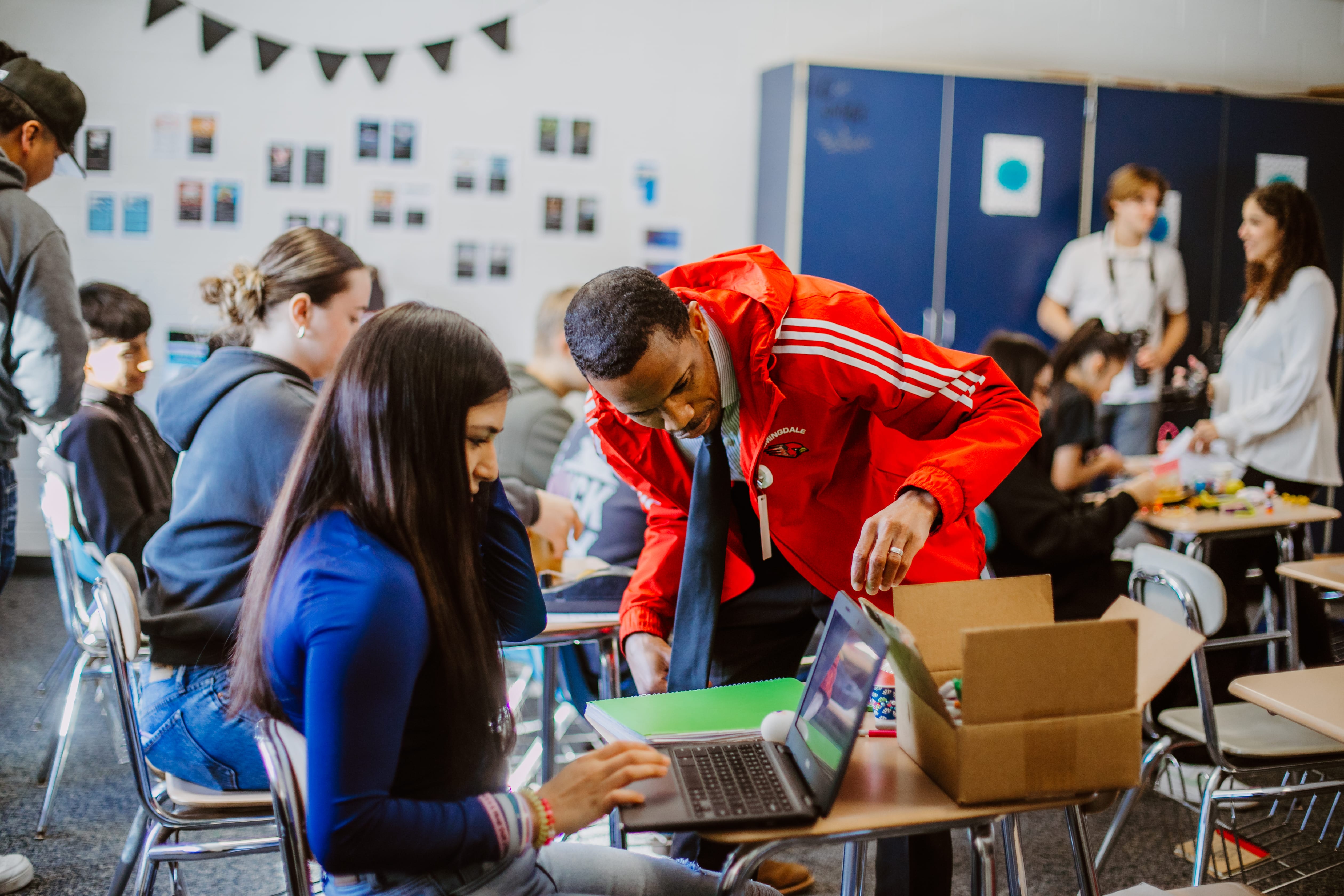 teacher helping a student on laptop