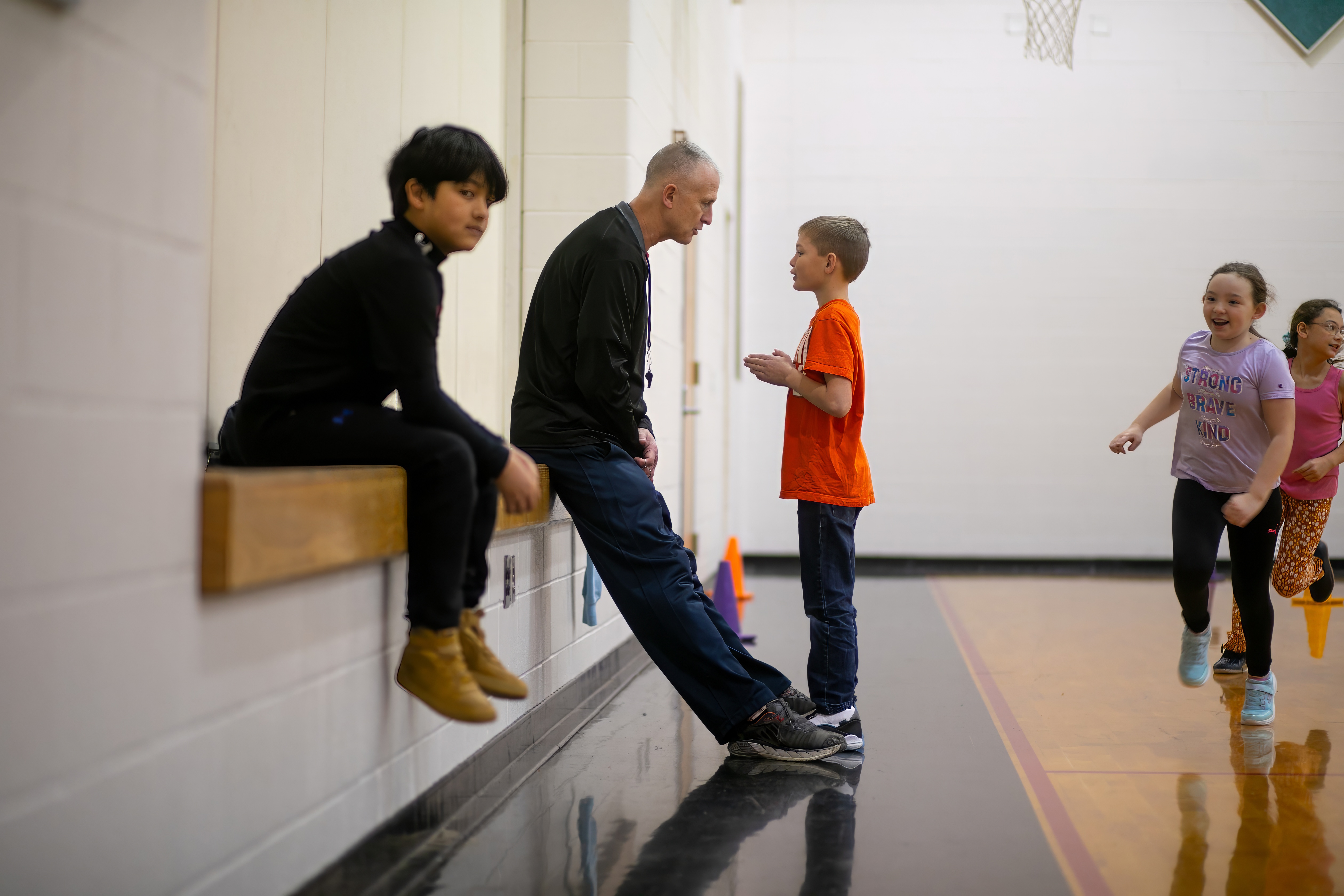 pe coach talking to students in gym