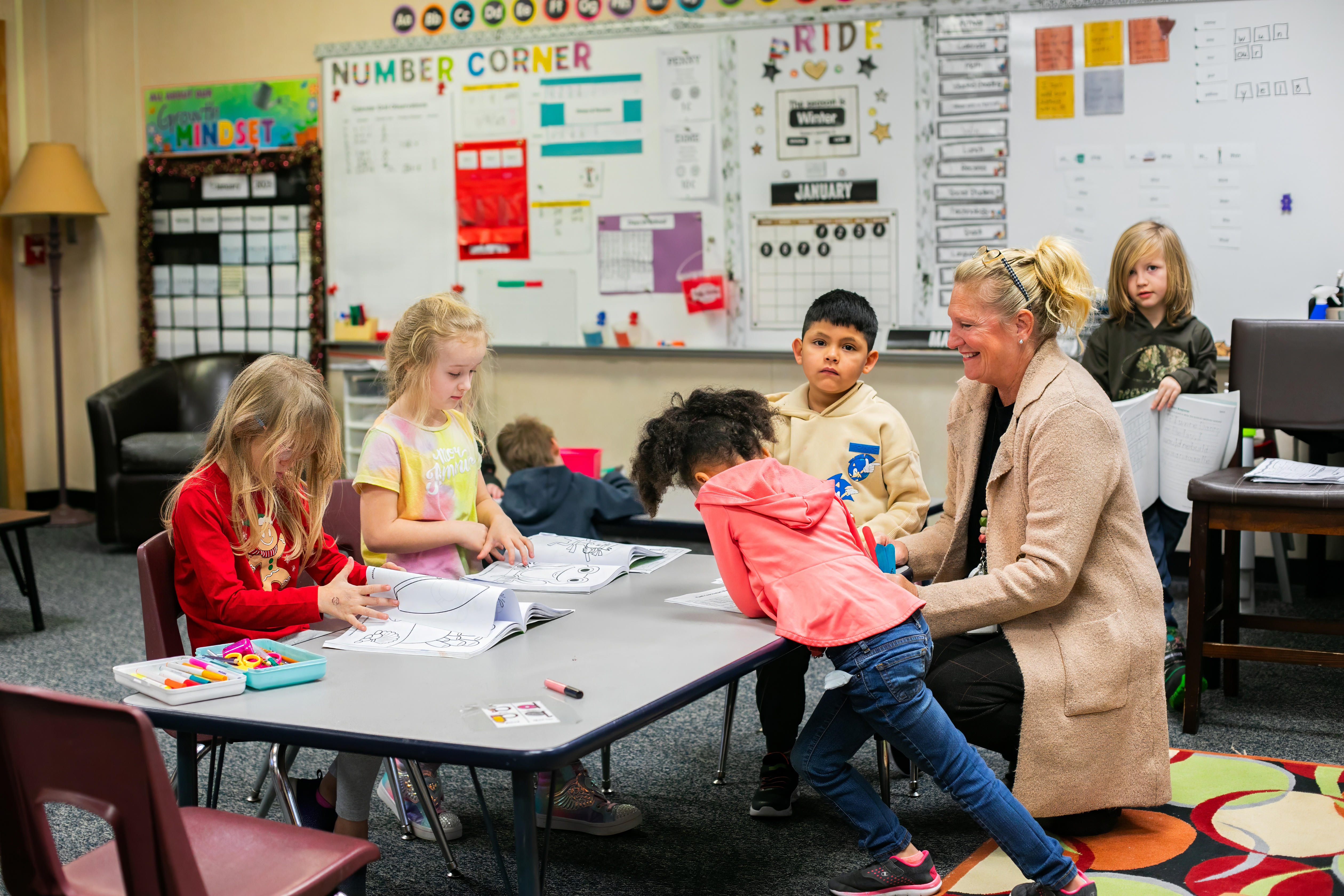 teacher smiling while working with students 