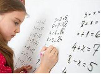 Young girl doing math on a whiteboard