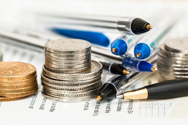 Stock photo with pens, paper, and coins