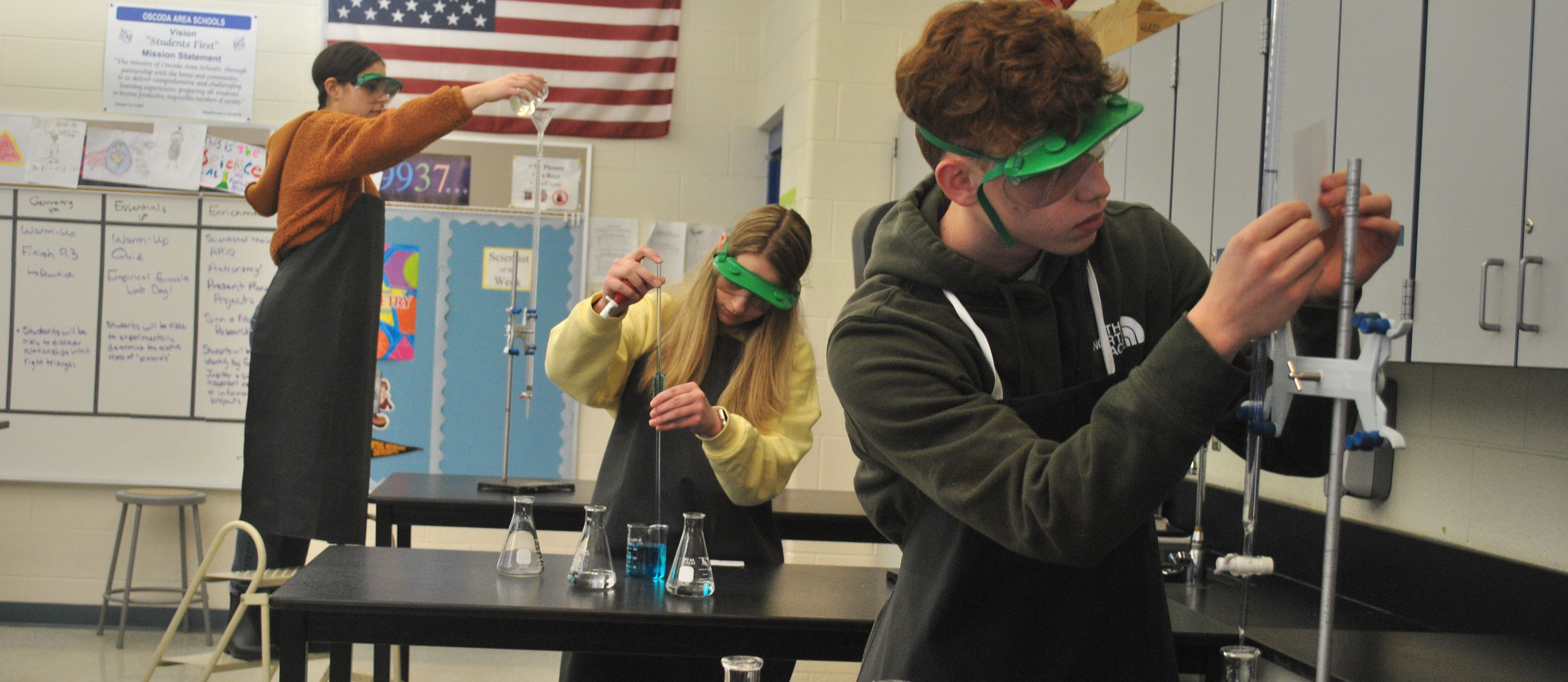 Students measuring beakers in Chemistry