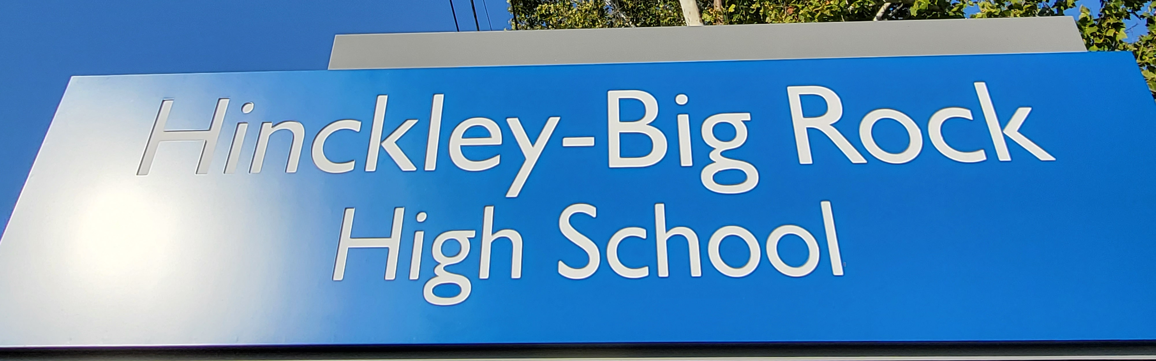 Hinckley-Big Rock High School sign with tree