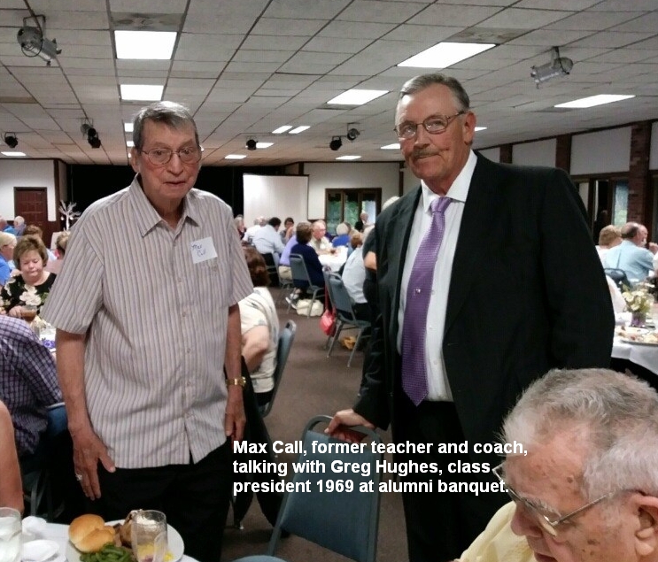 Max Call, former teacher and coach, talking with Greg Hughes, class president 1969 at alumni banquet