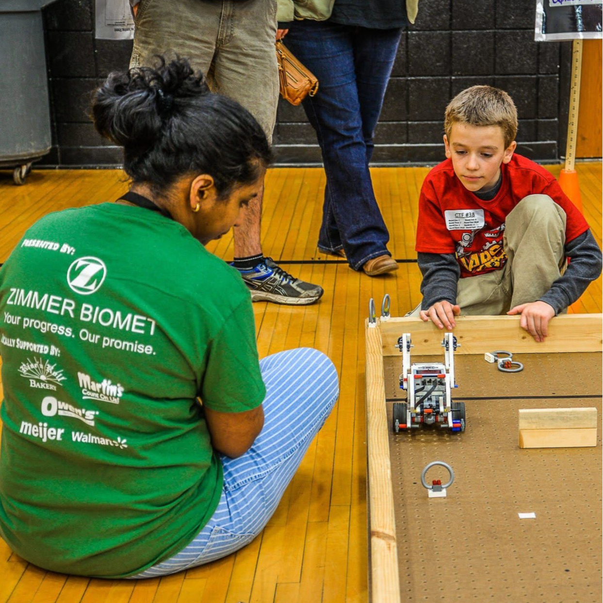 Student and chaperone observing a robot at robotics competition