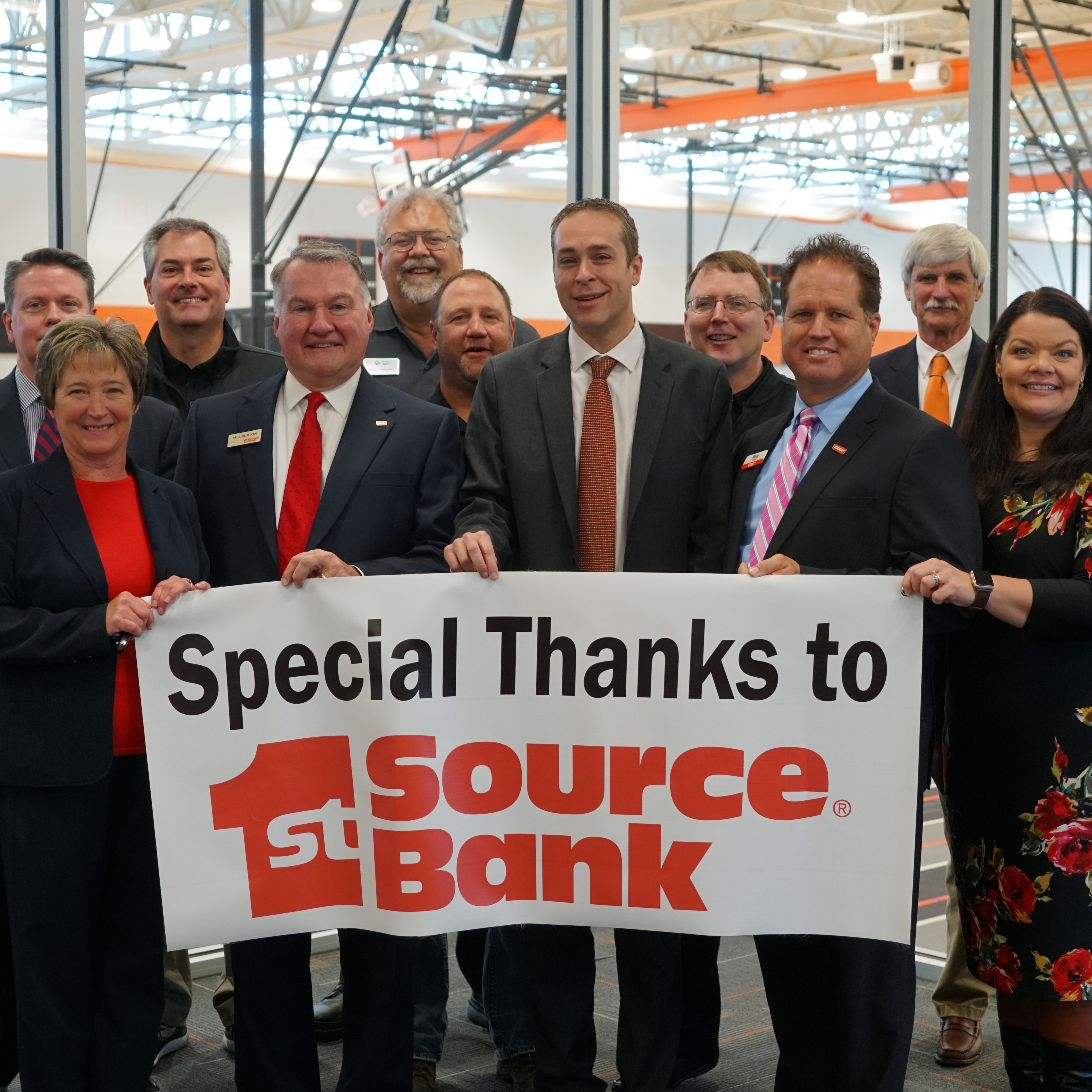 team holding up special thanks to 1st source bank banner