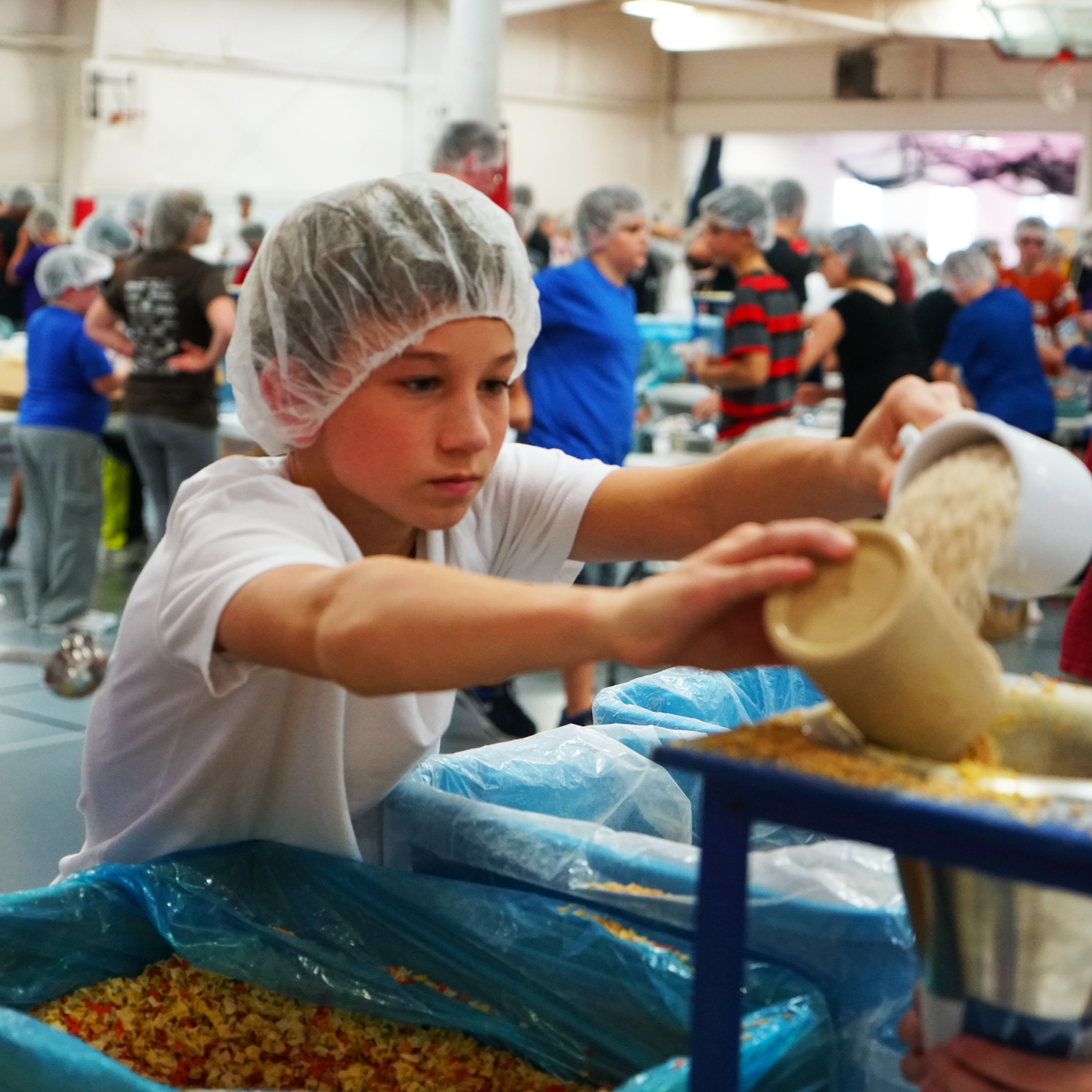 students in hair nets learning about food preparation