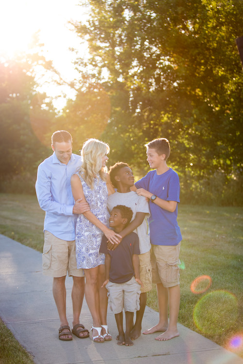 Hoffert Family standing together on a sidewalk in the light of the sunset. 