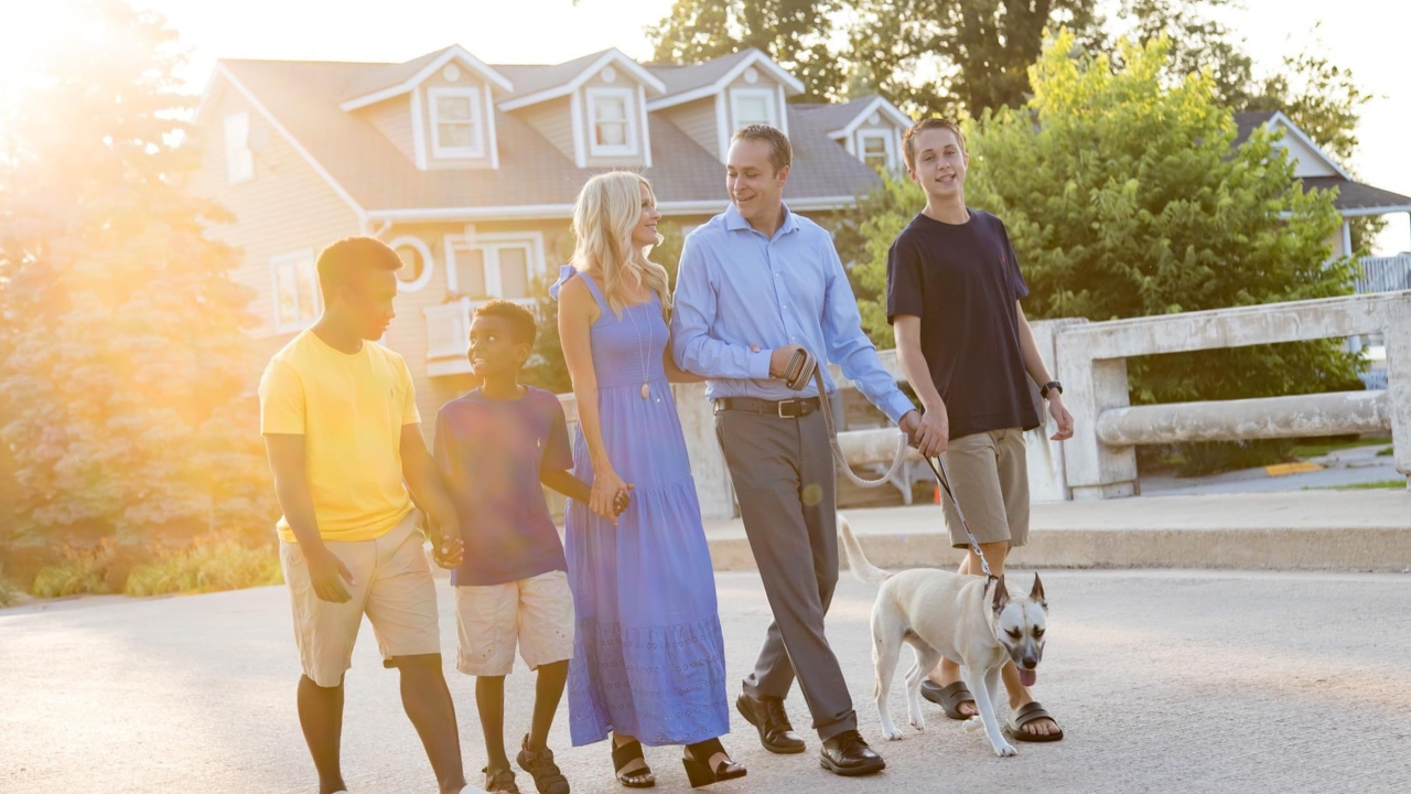 Hoffert Family walking their dog across a bridge together while holding hands