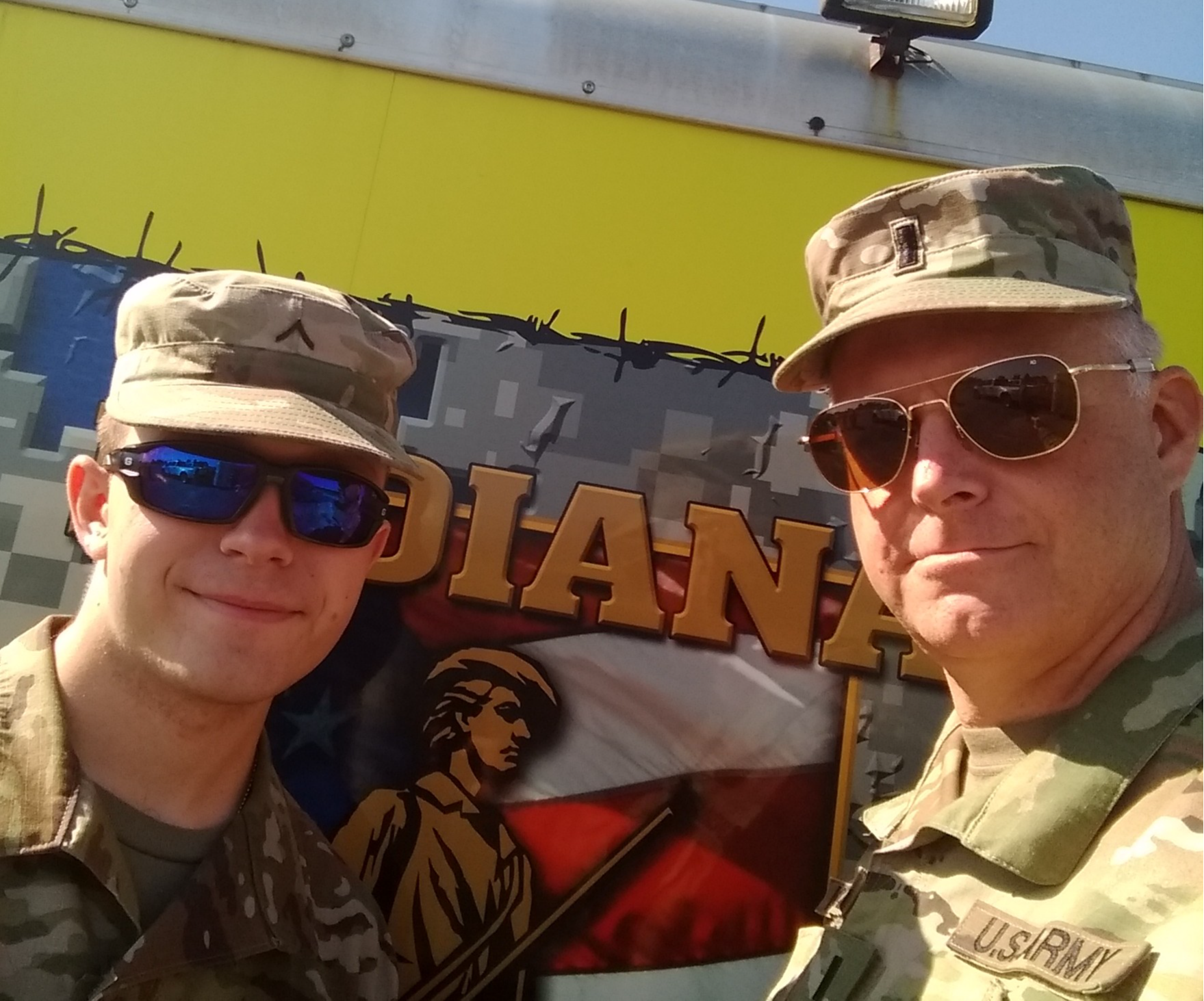 JROTC instructor with a student in front of imagery of the US flag