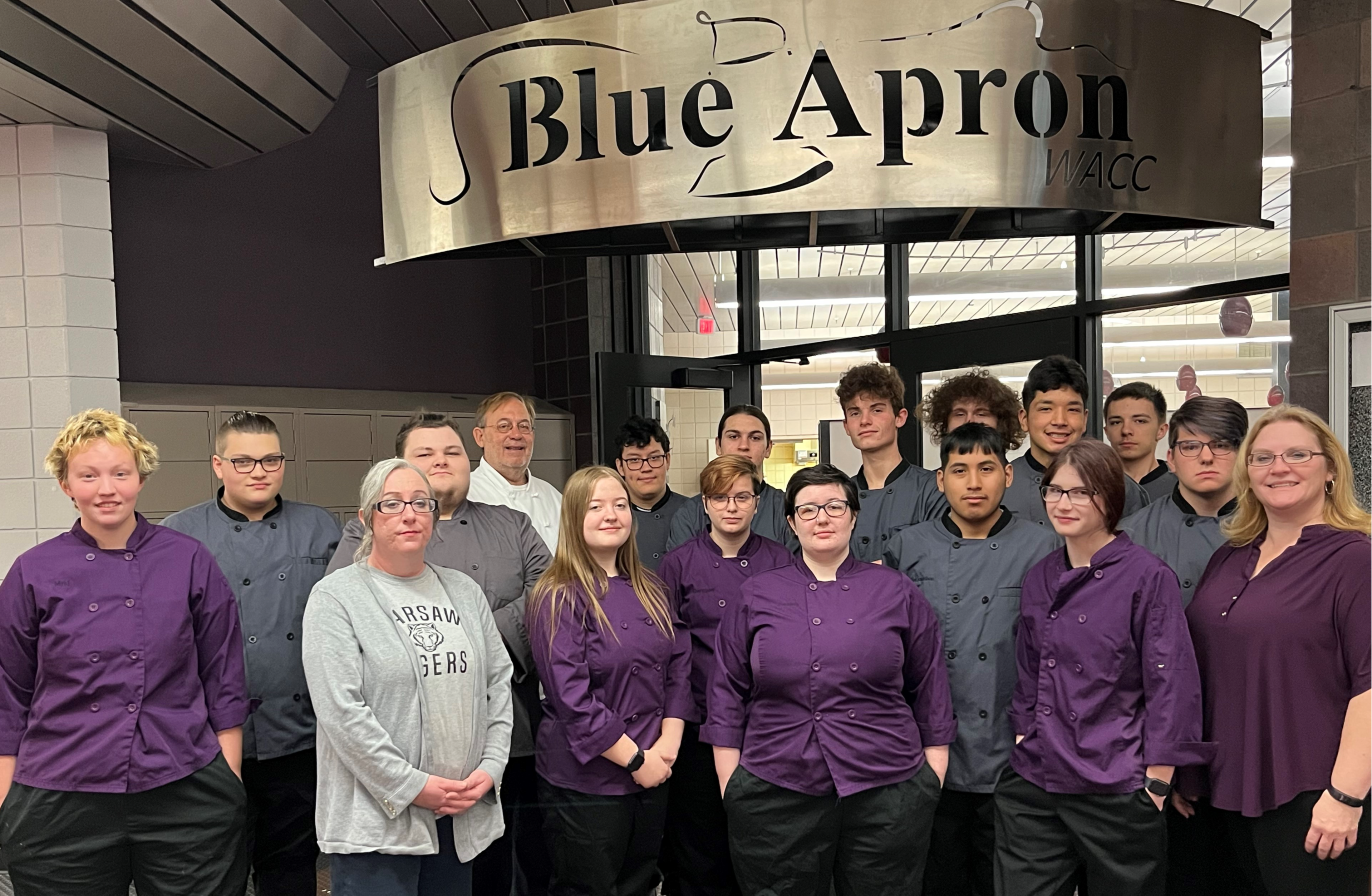 ADVANCED CULINARY ARTS students pose at the entrance to the blue apron