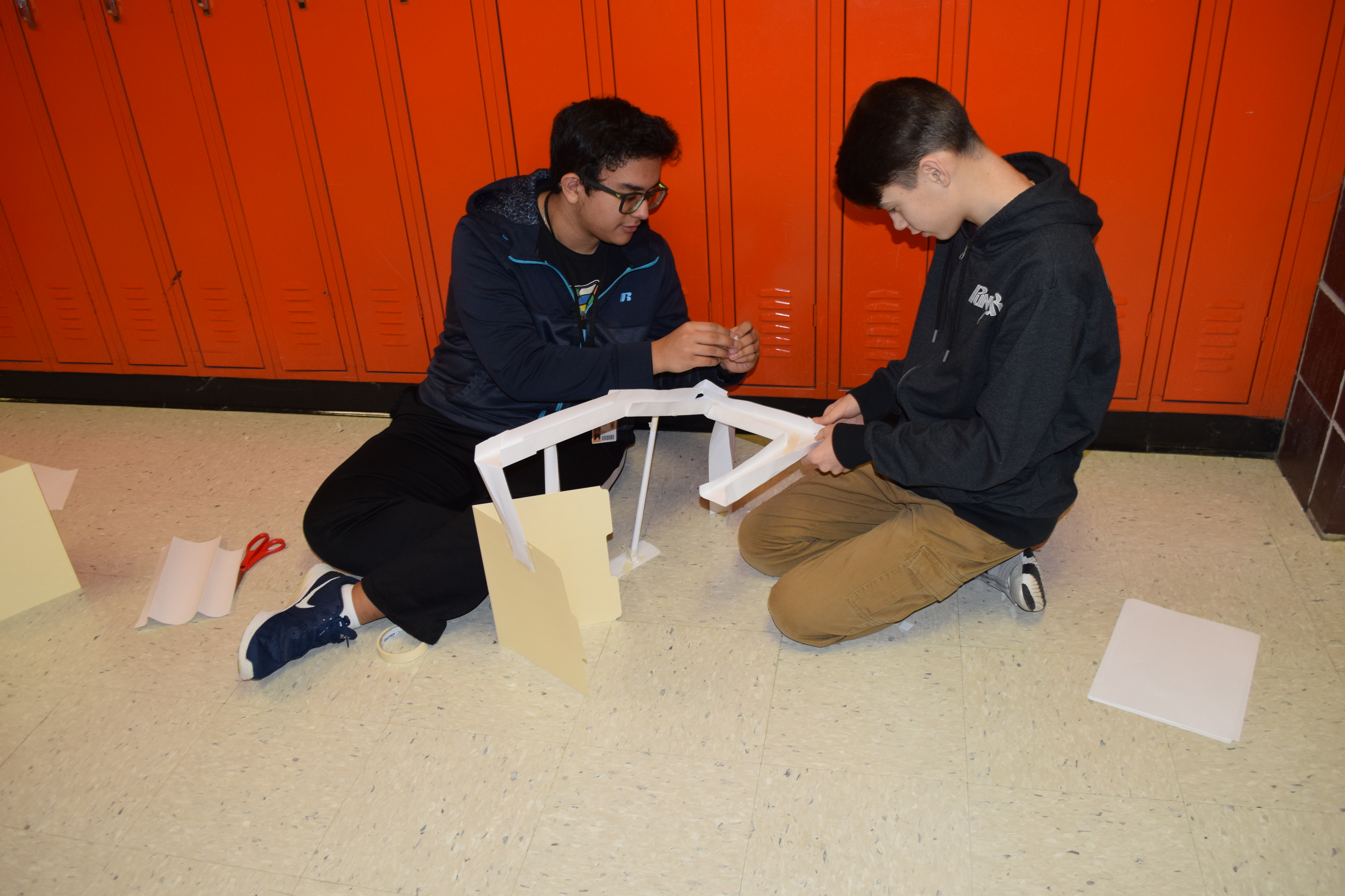 Engineering Technology students working on a project together on the floor