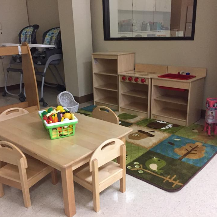 toddler play room with wooden table and chairs and shelves