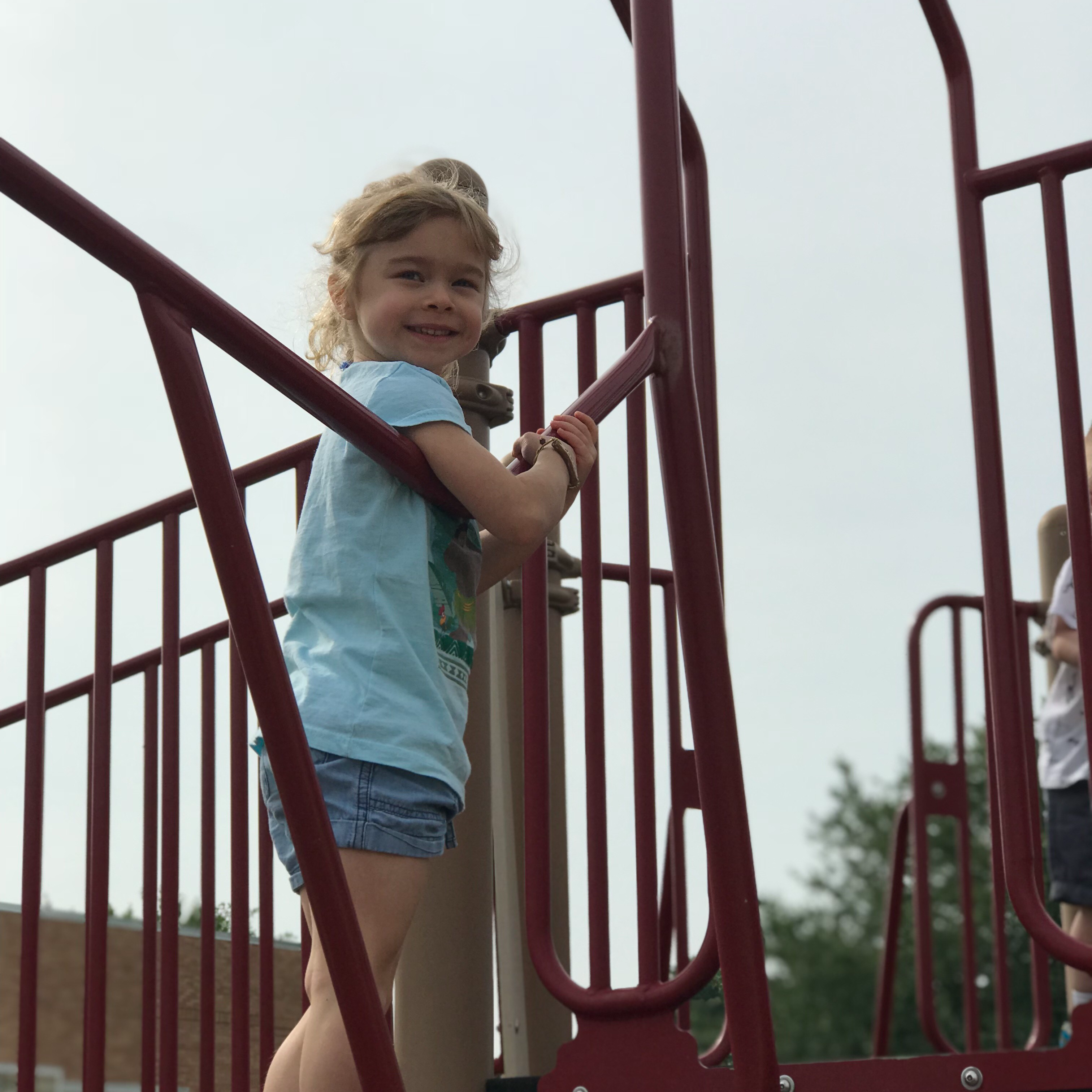 child posing on playground equipment