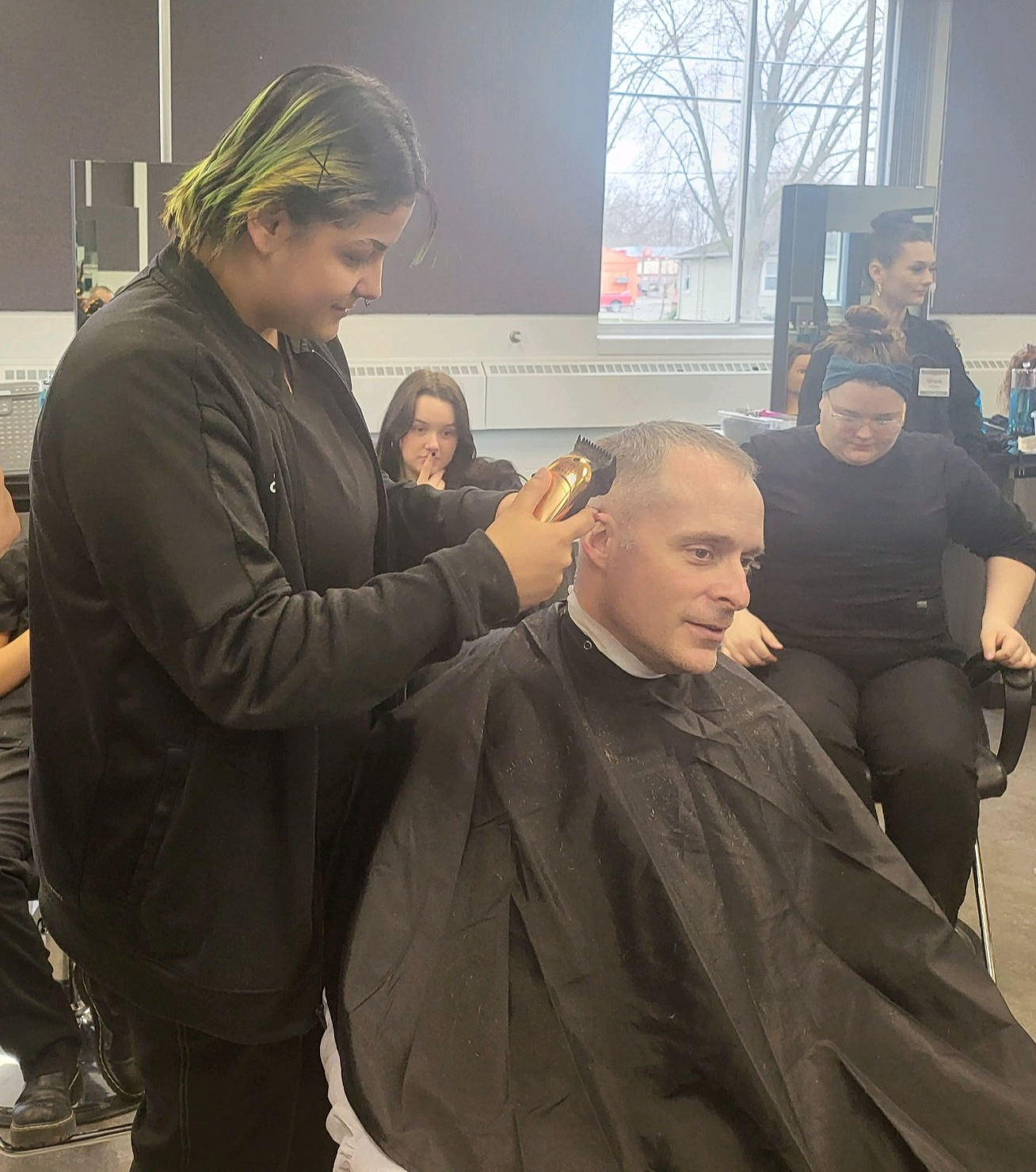 student practicing barber cut on a client