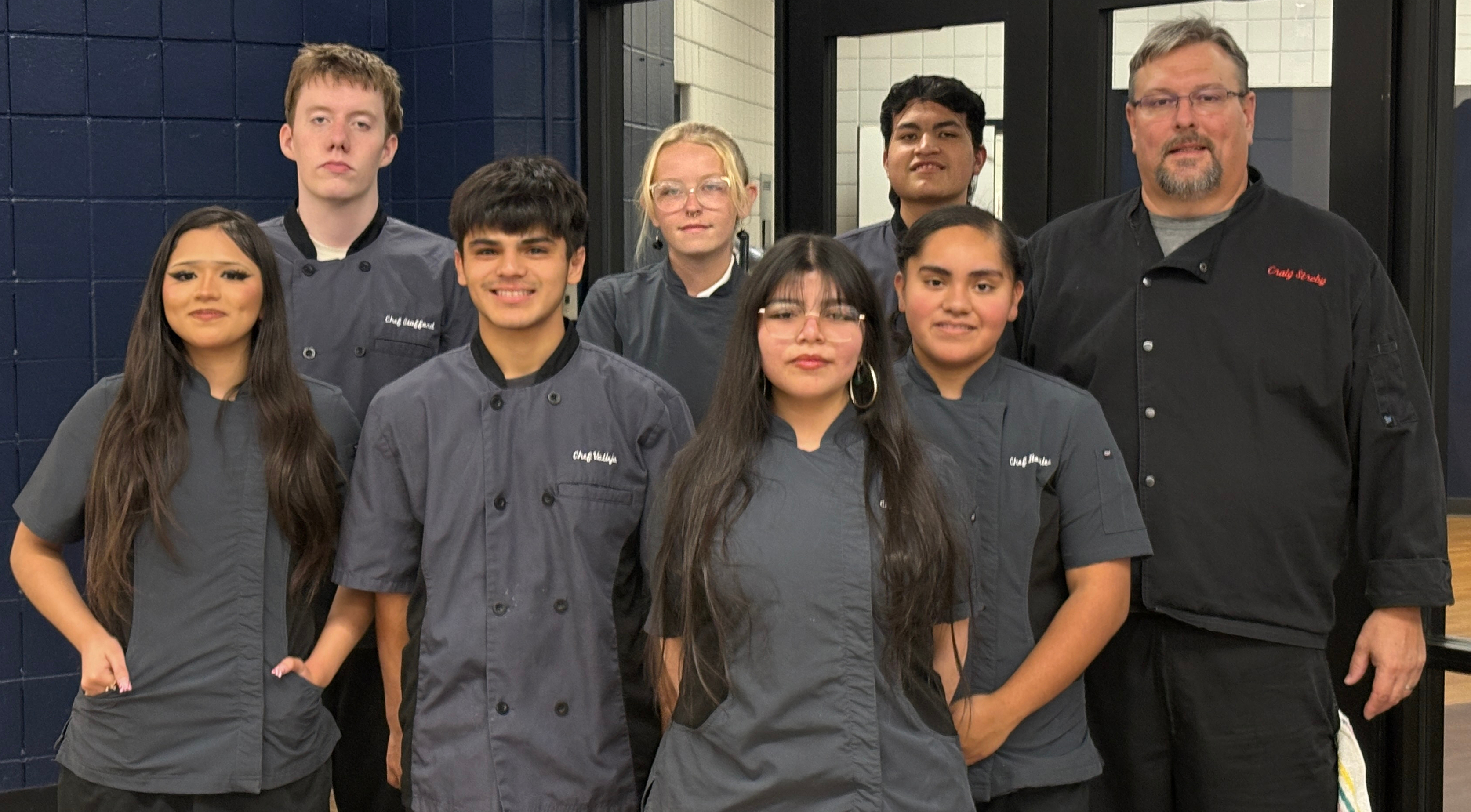 ADVANCED CULINARY ARTS students pose at the entrance to the blue apron