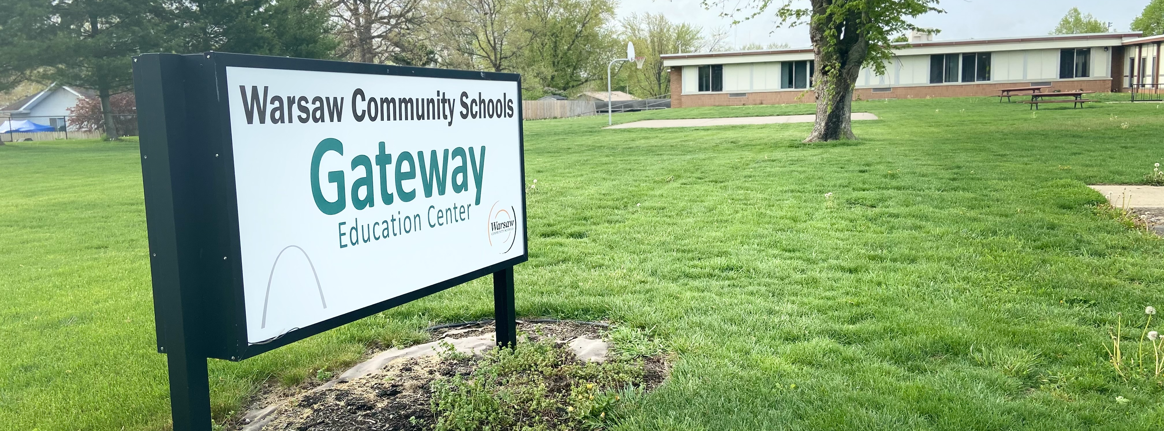 sign for warsaw community schools gateway education center on the grounds outside of the building