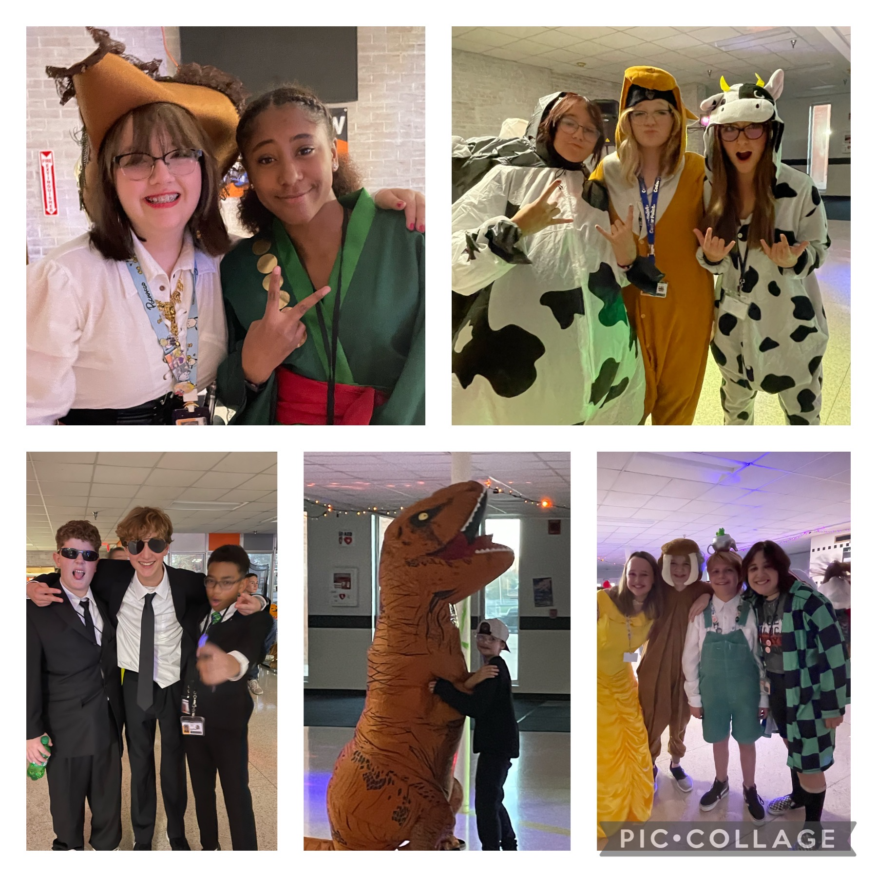 Students pose in their halloween costumes. A pirate and an earth bender, three cows, three FBI agents, a t rex, Belle, a dog, Greg from Over the Garden Wall, and an anime character