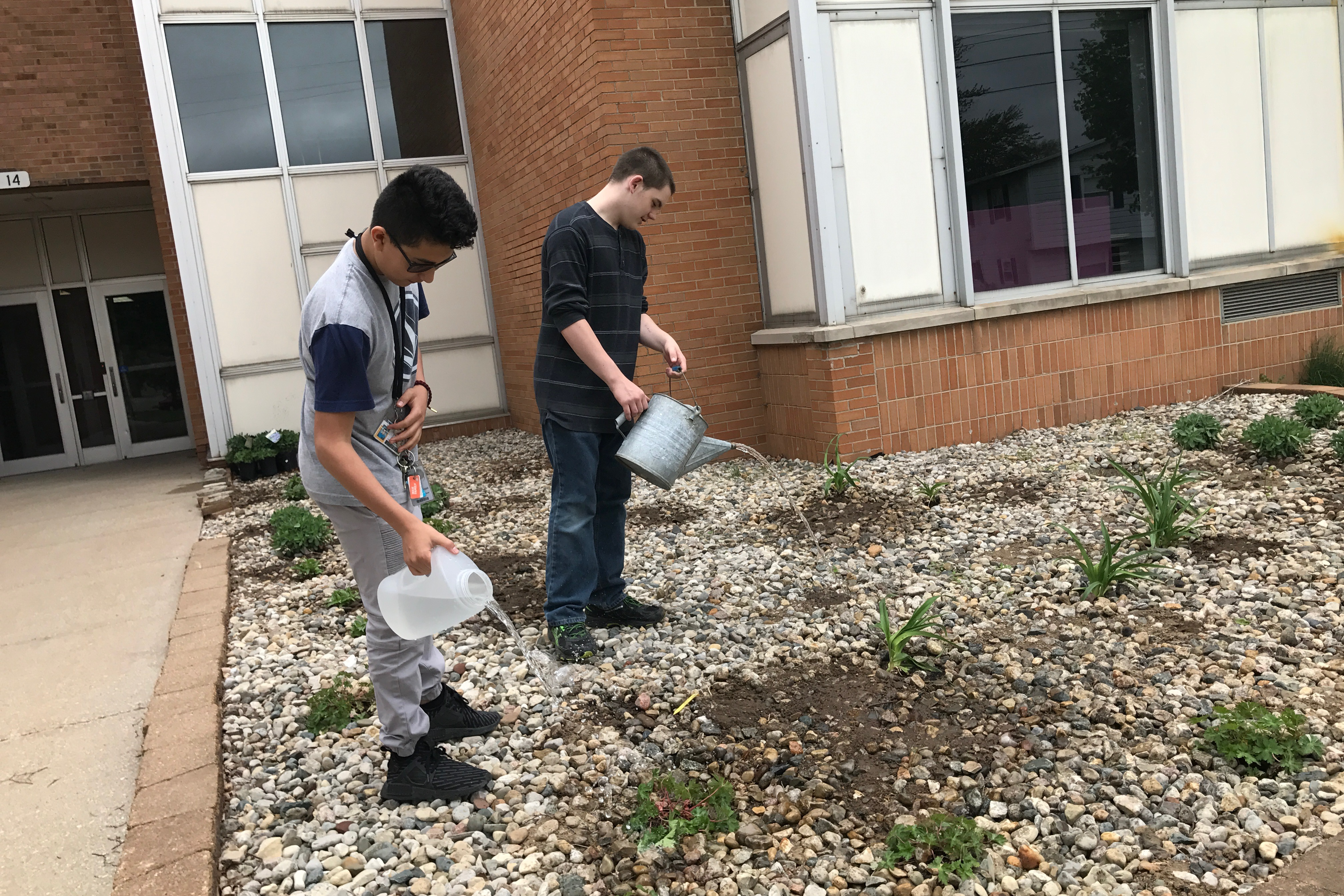 Students watering the garden outside the school