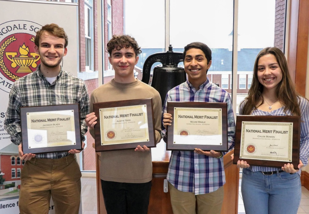 A photo of students with award plaques