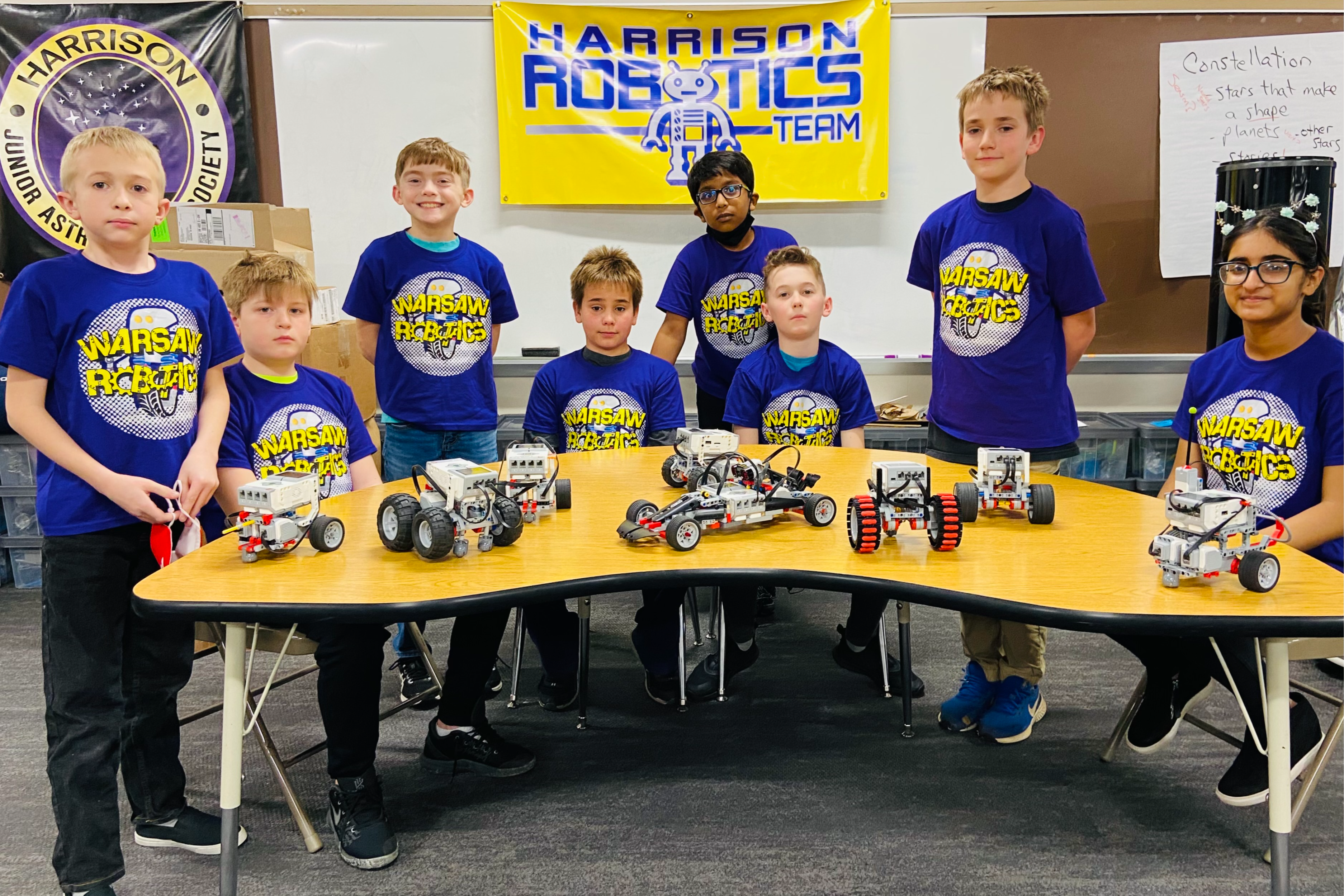 the Warsaw robotics club Harrison Robotics team posing at a table with the robots they built