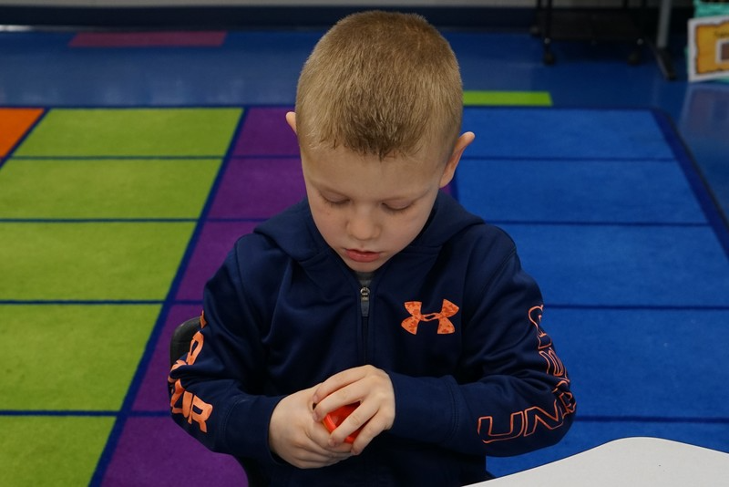 Student looking down at toy