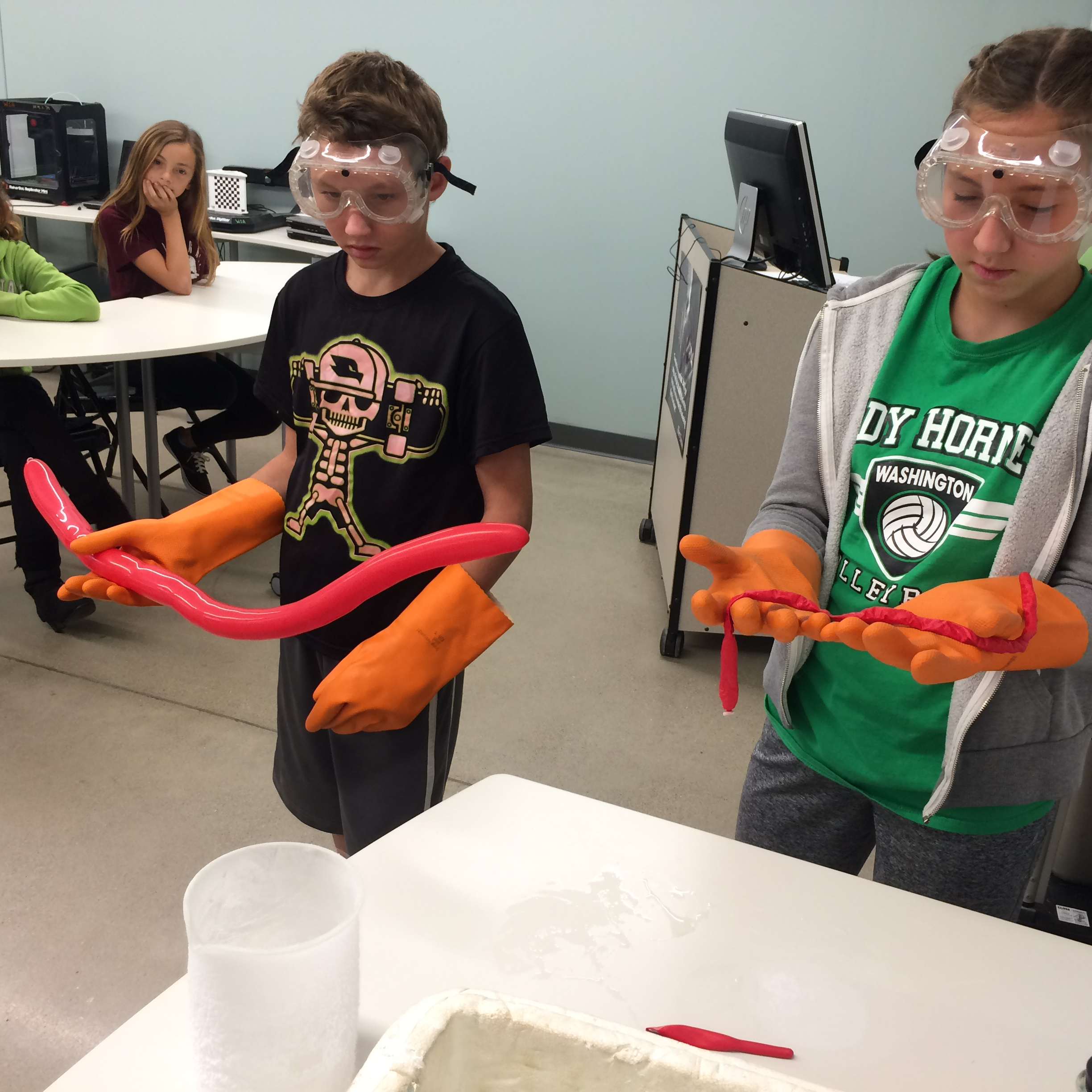 Students in gloves and goggles holding a balloon