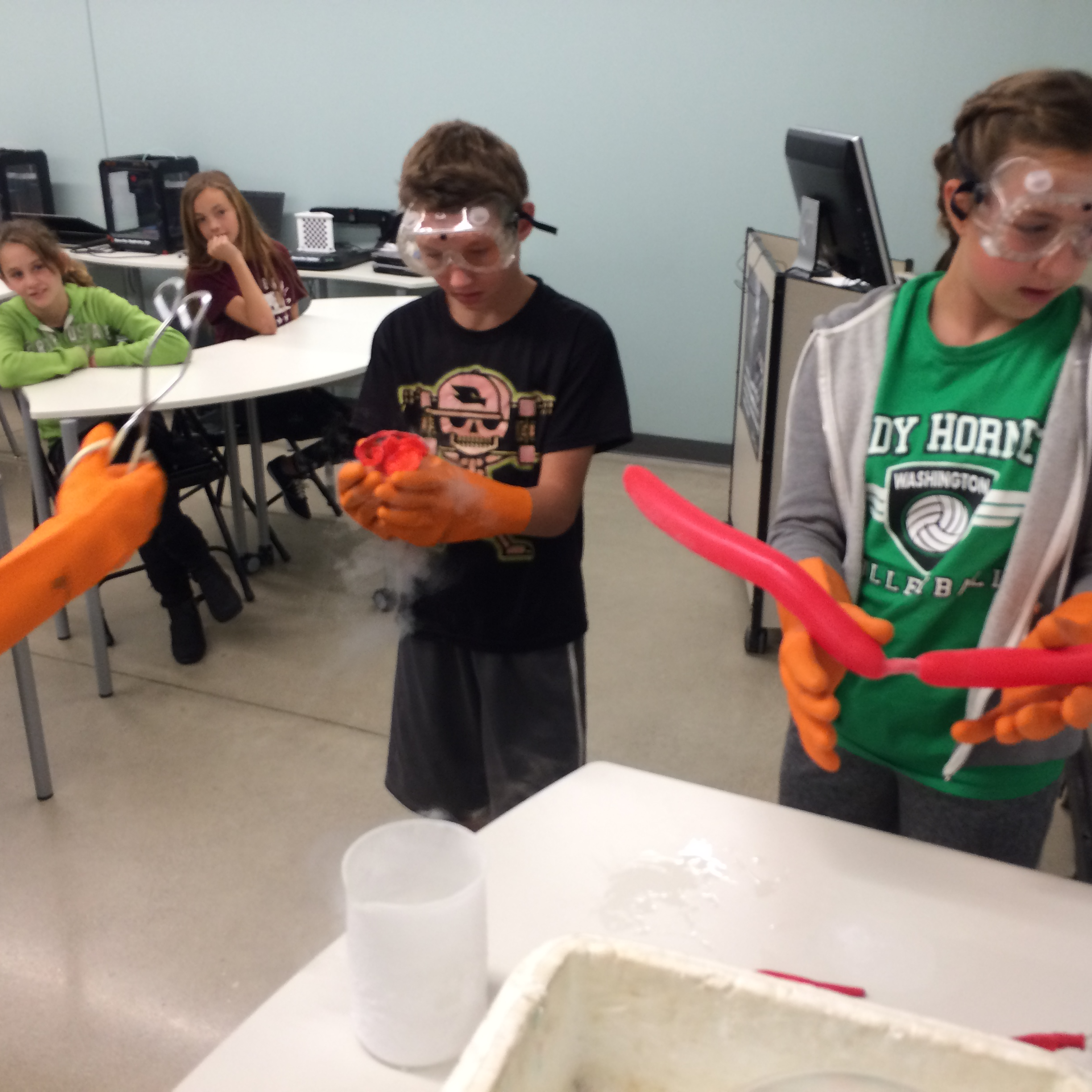 Students in gloves and goggles holding a balloon