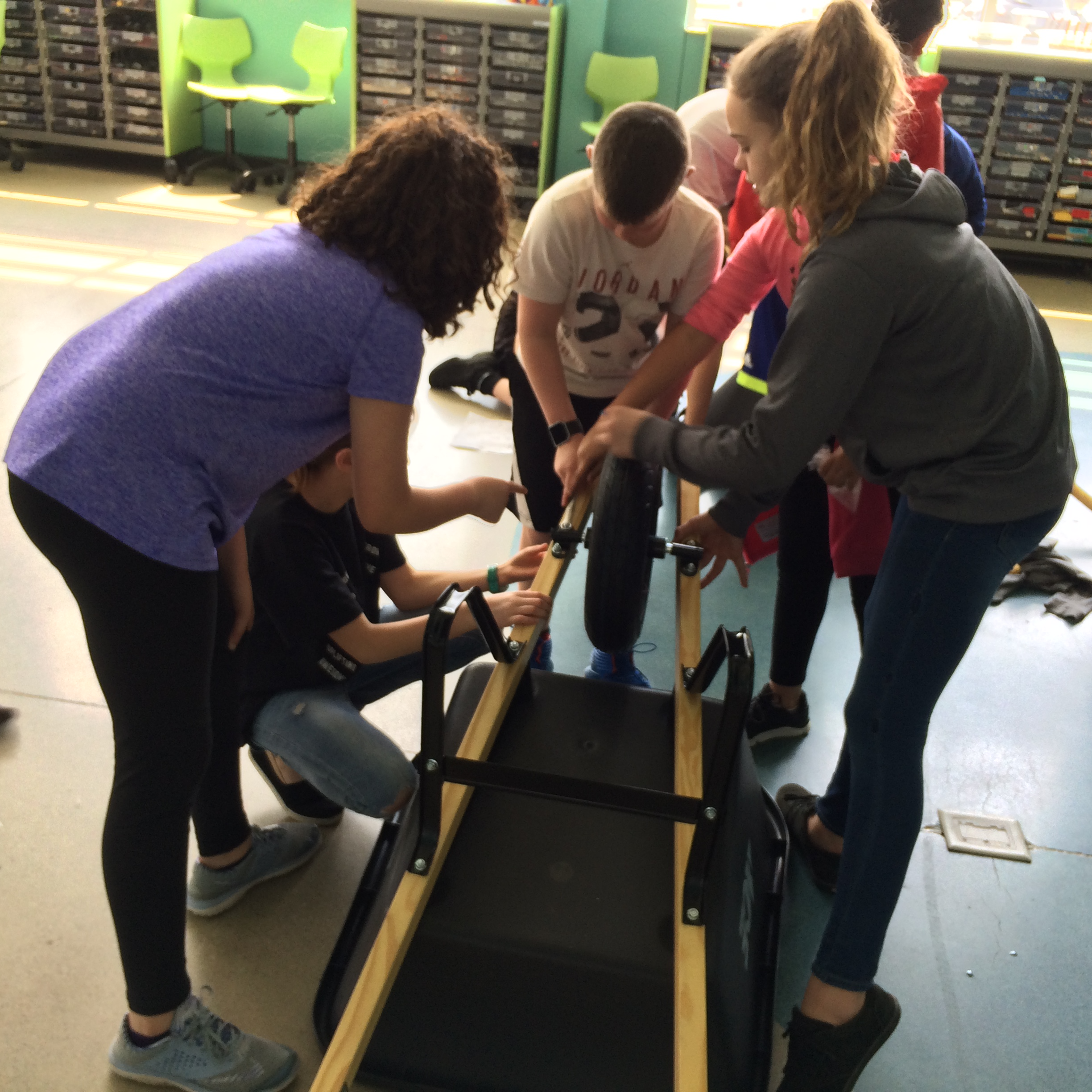 Students working on maintenance to a wheelbarrow 