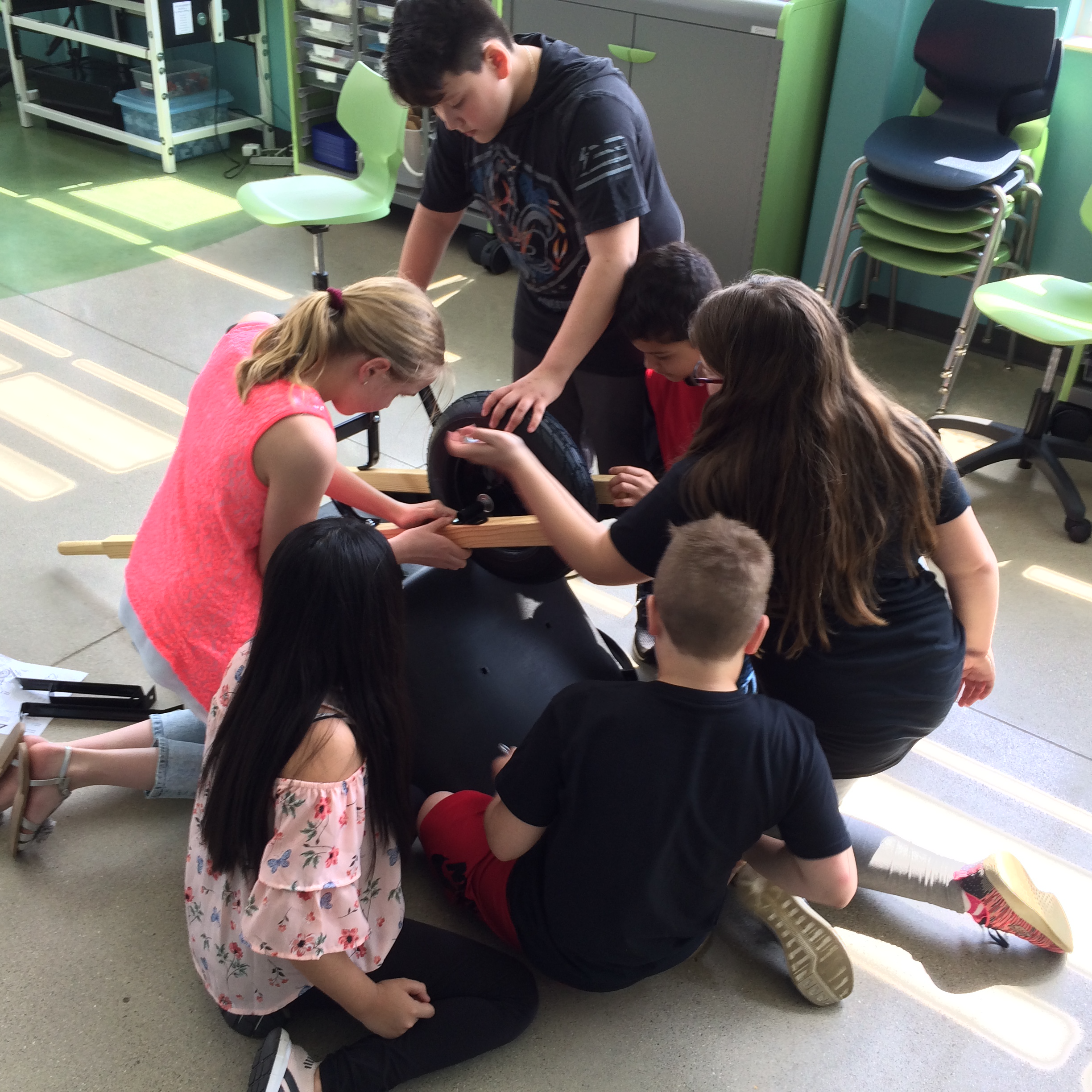 Students working on maintenance to a wheelbarrow 