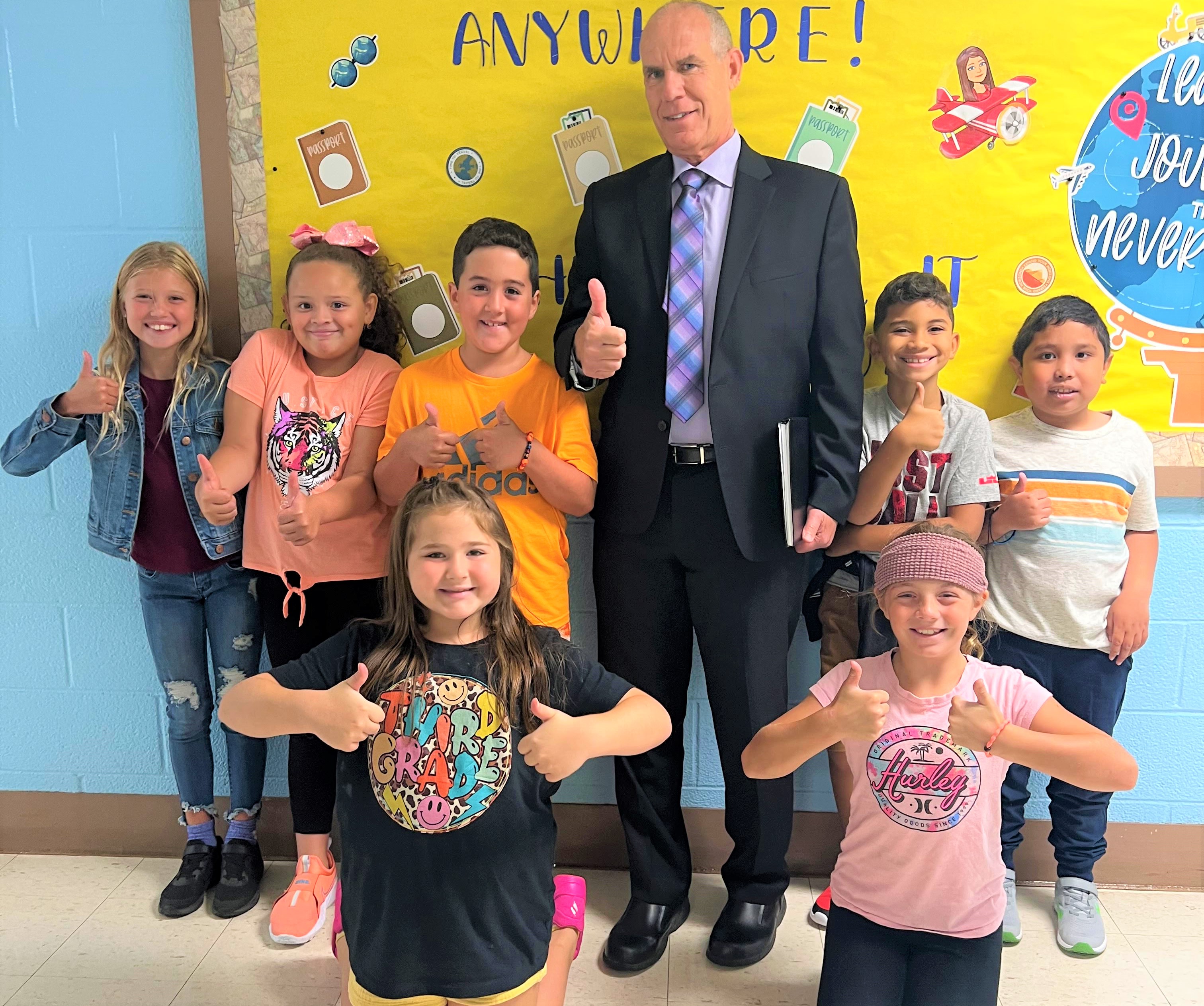 Dr. Corbett and students from Birchwood Elementary giving a thumbs up