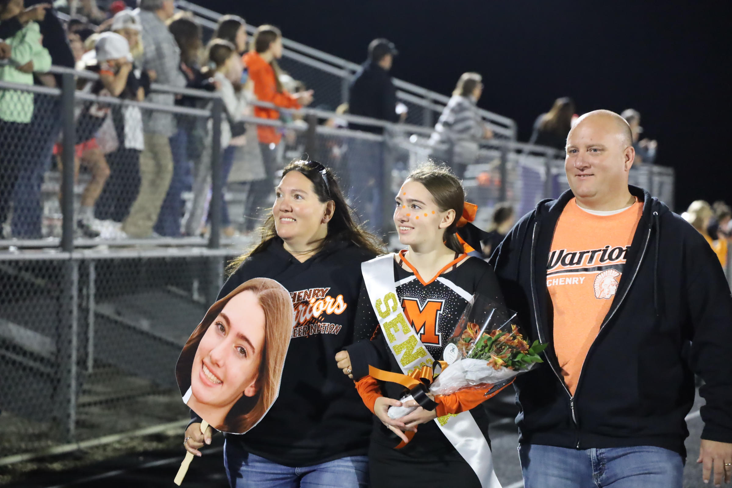 Parents with their cheer student on senior night