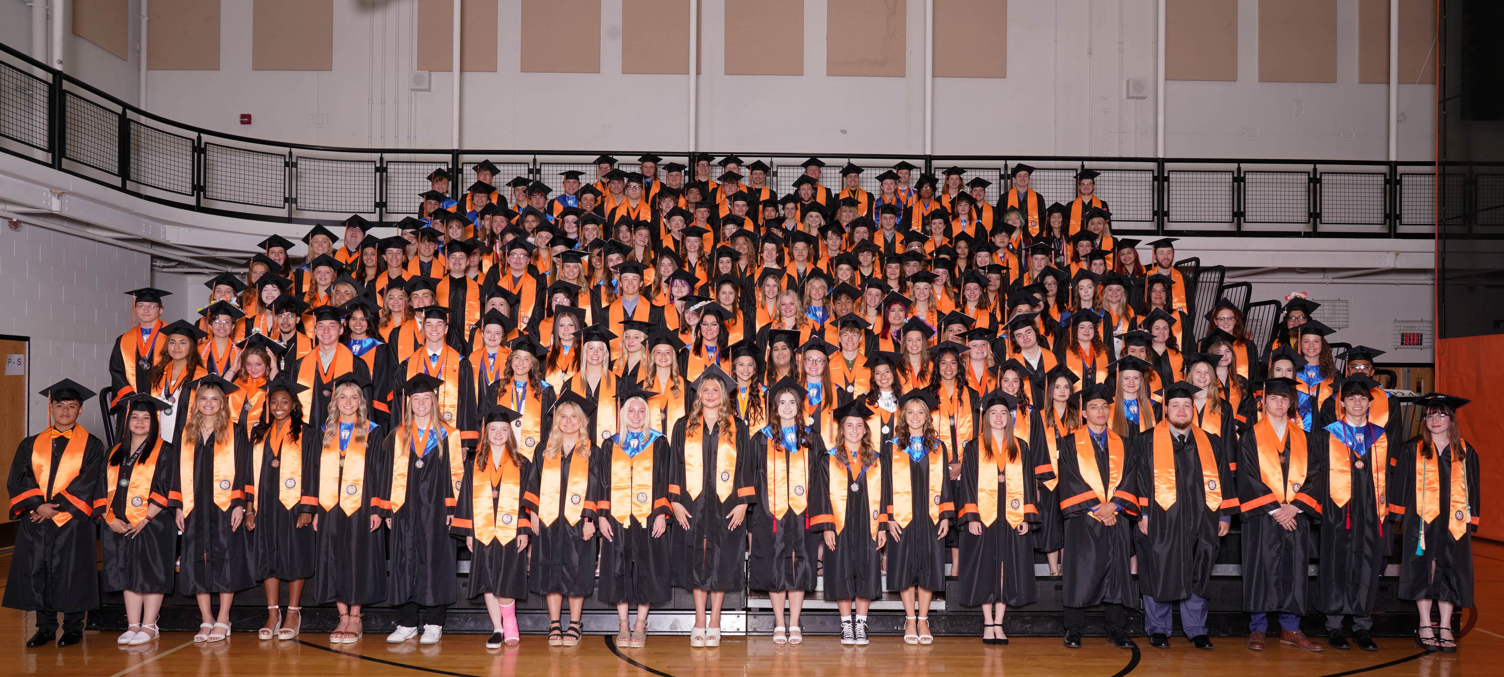 Distinguished Warrior Graduates in graduation caps and gowns with Distinguished Warrior orange stole
