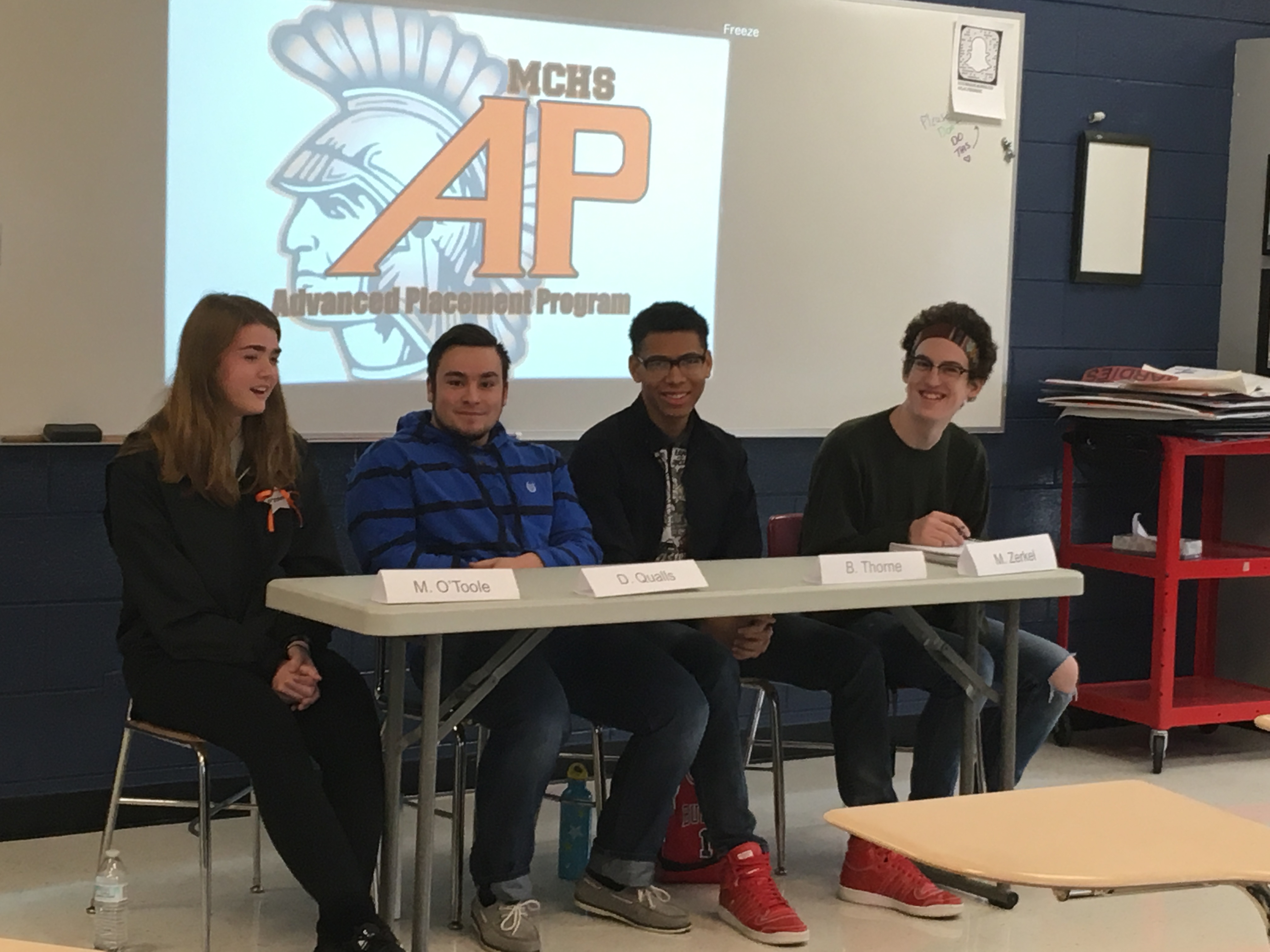 Students sitting at a panel in front of an AP logo
