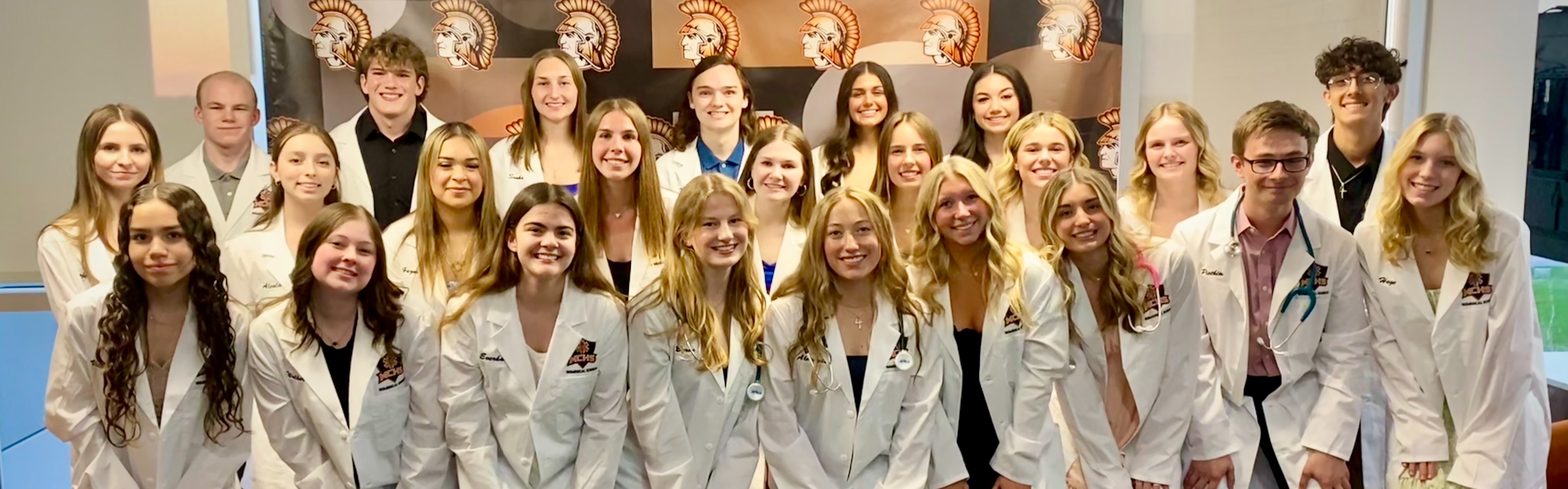 Students in white coats at white coat ceremony