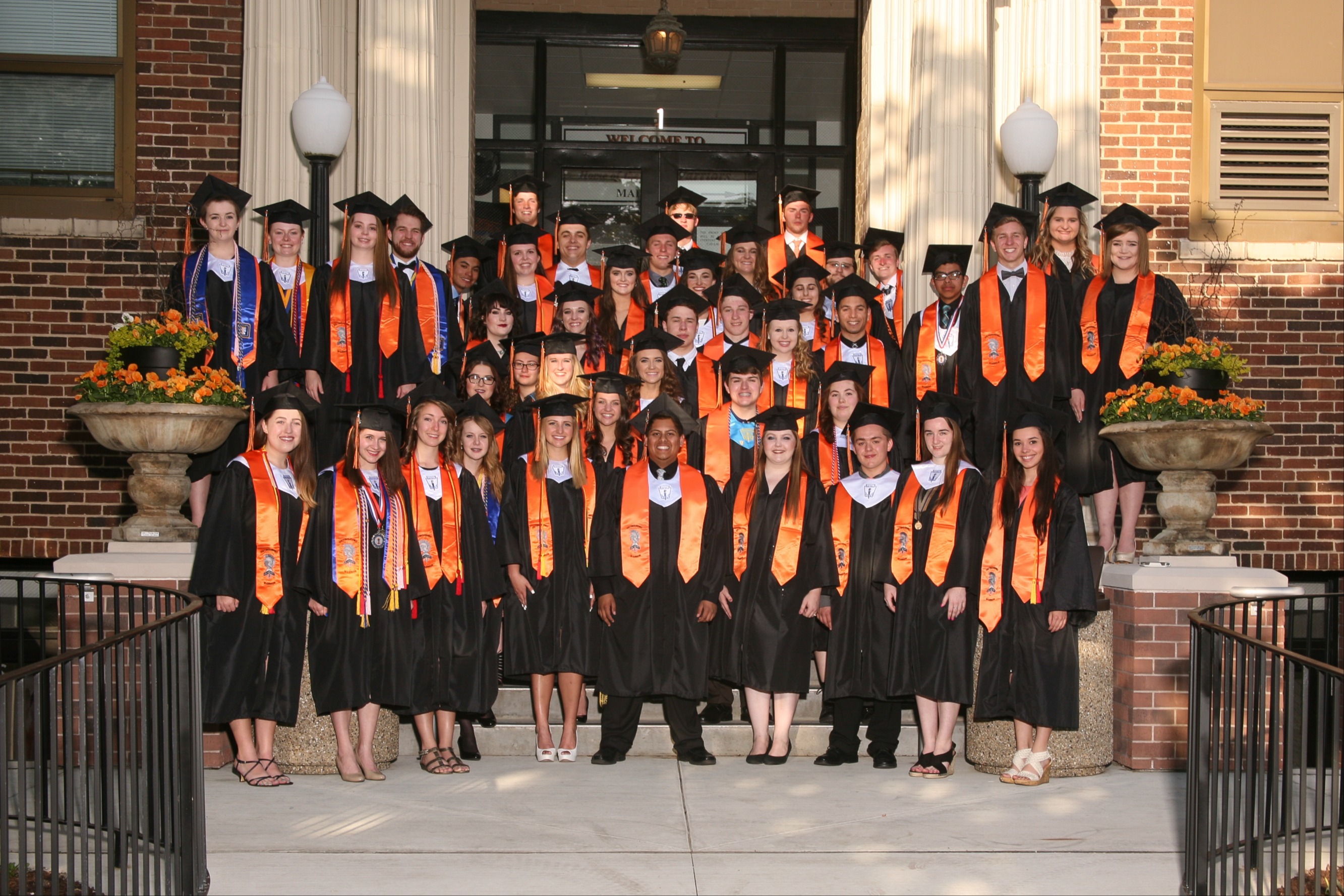 Class of 2016 Distinguished Warriors East Campus in stoles and caps and gowns in front of East Campus