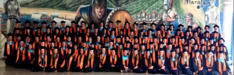 Distinguished Warriors in stoles in front of wall painted with Warriors wearing caps and gowns. Class fo 2015