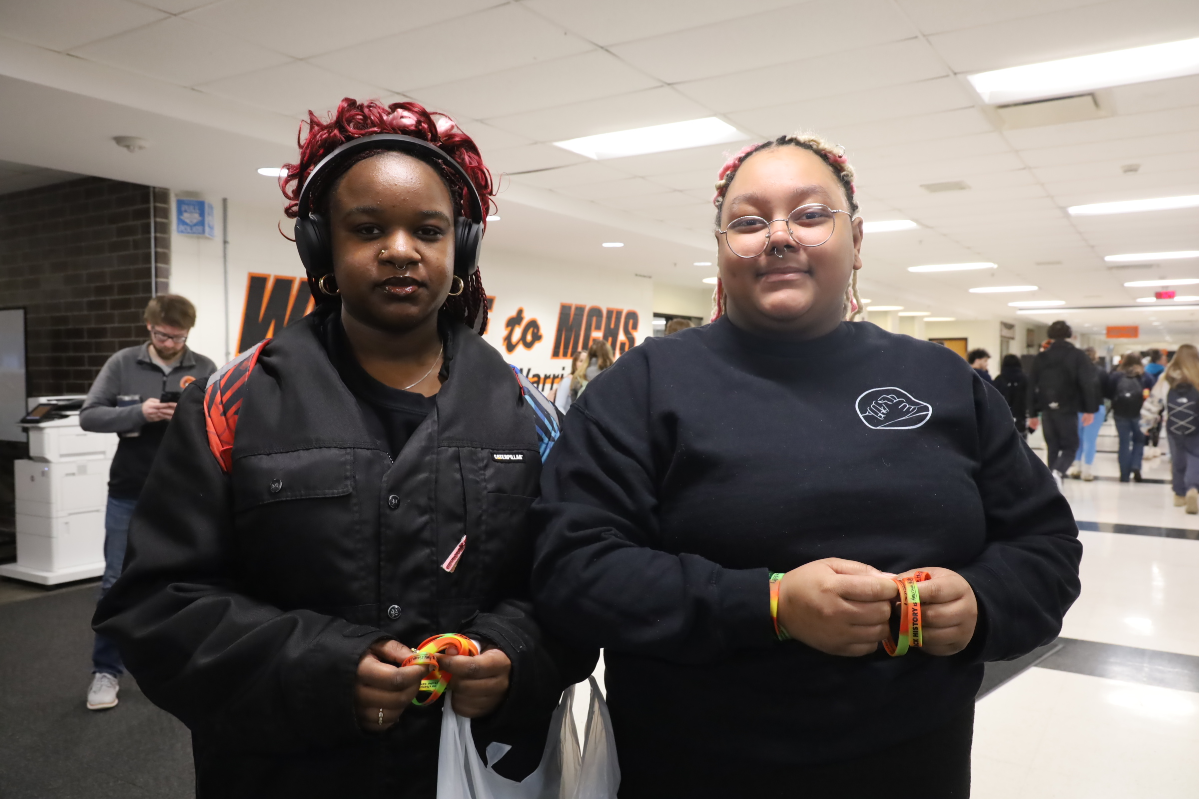 Two students holding Black History Month bracelets