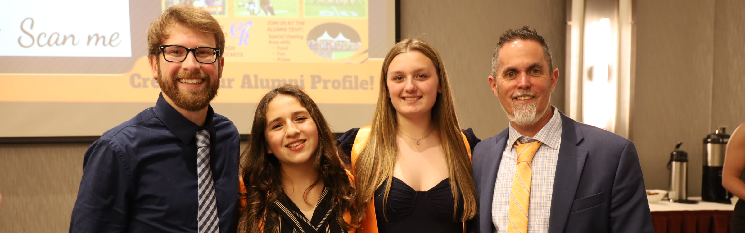 Two adults with two students with orange stoles 