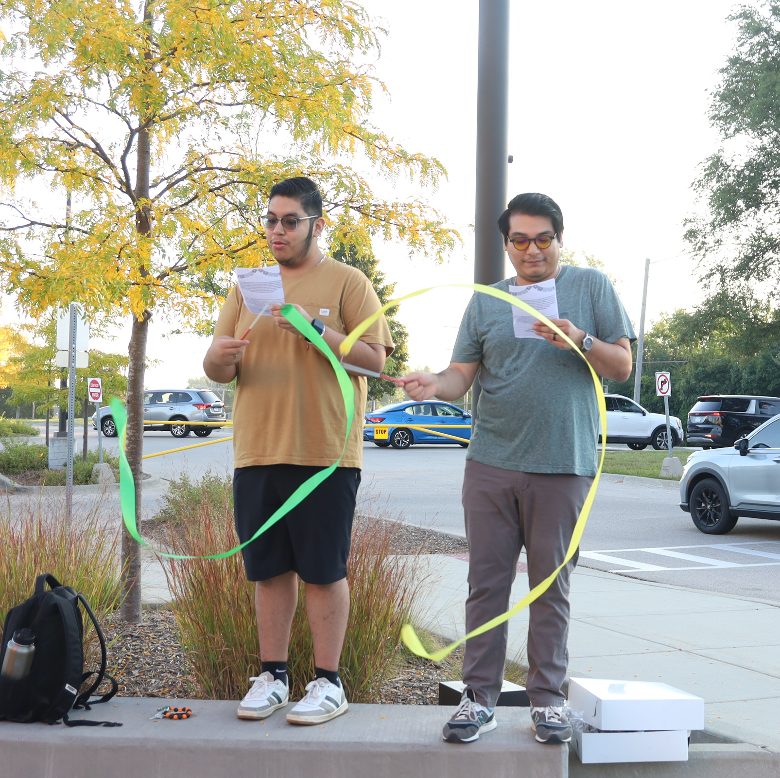 Student and staff member reading and waving ribbons