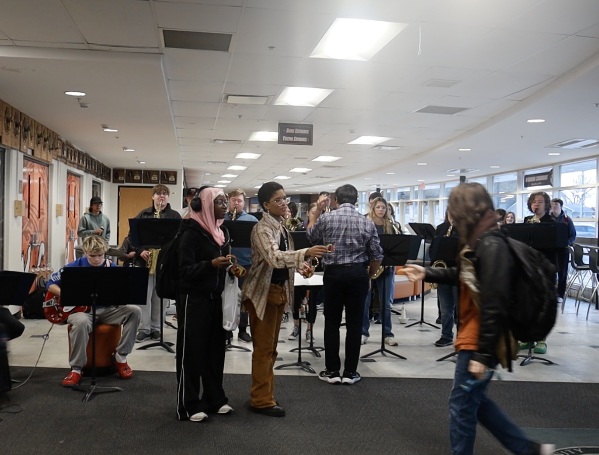 Students handing out bracelets while band is playing