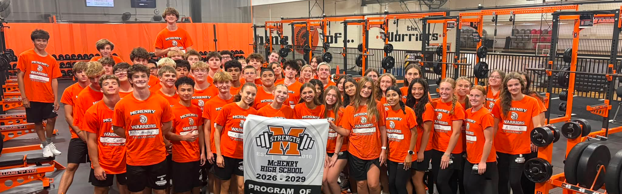 Strength studnets holding program of excellence banner