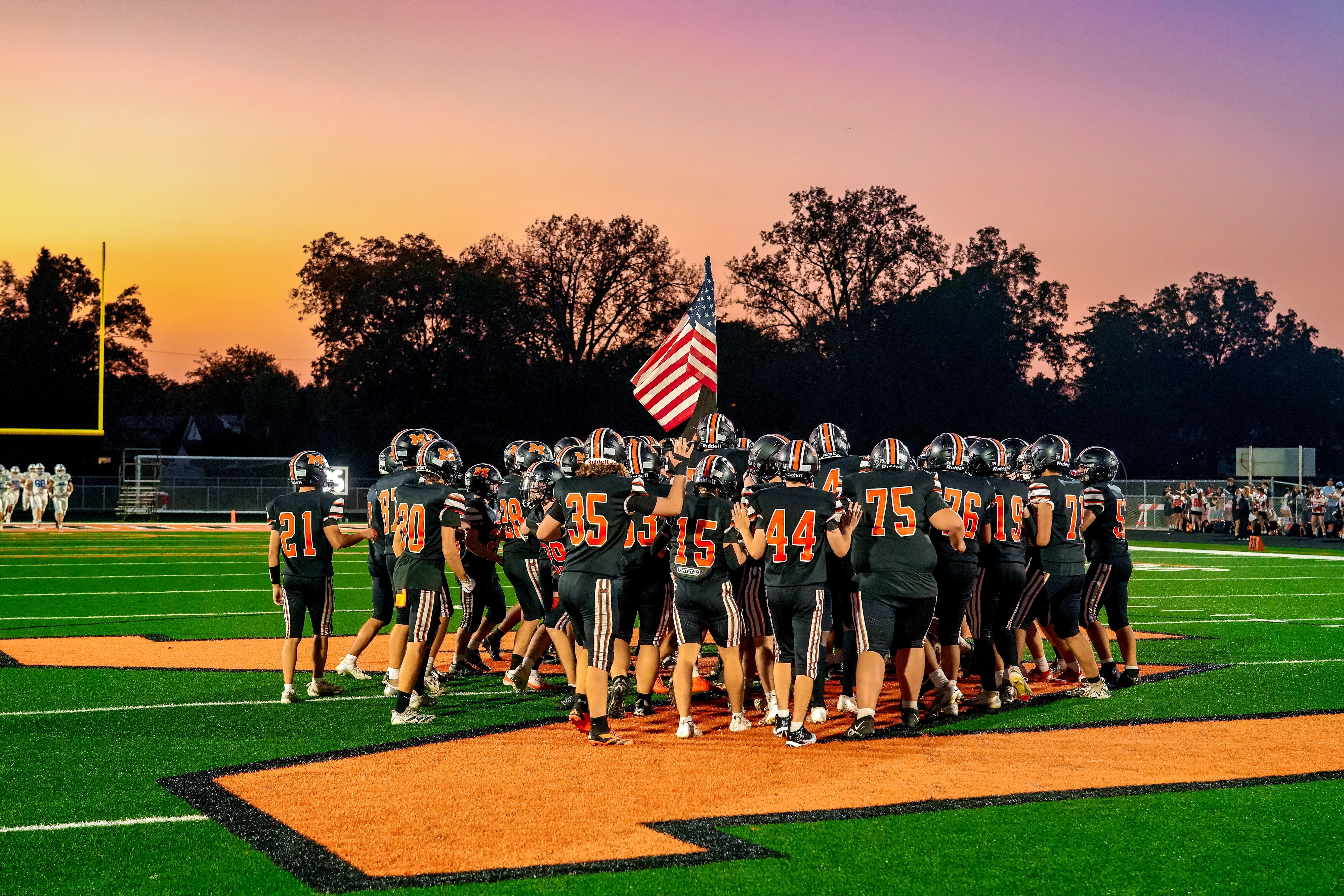 Football field with American flag at sunset 