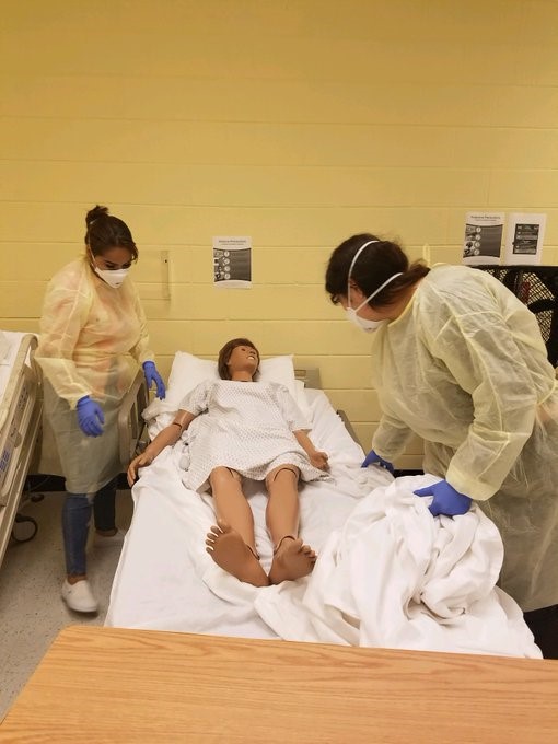 student nurses helping a dummy patient in bed