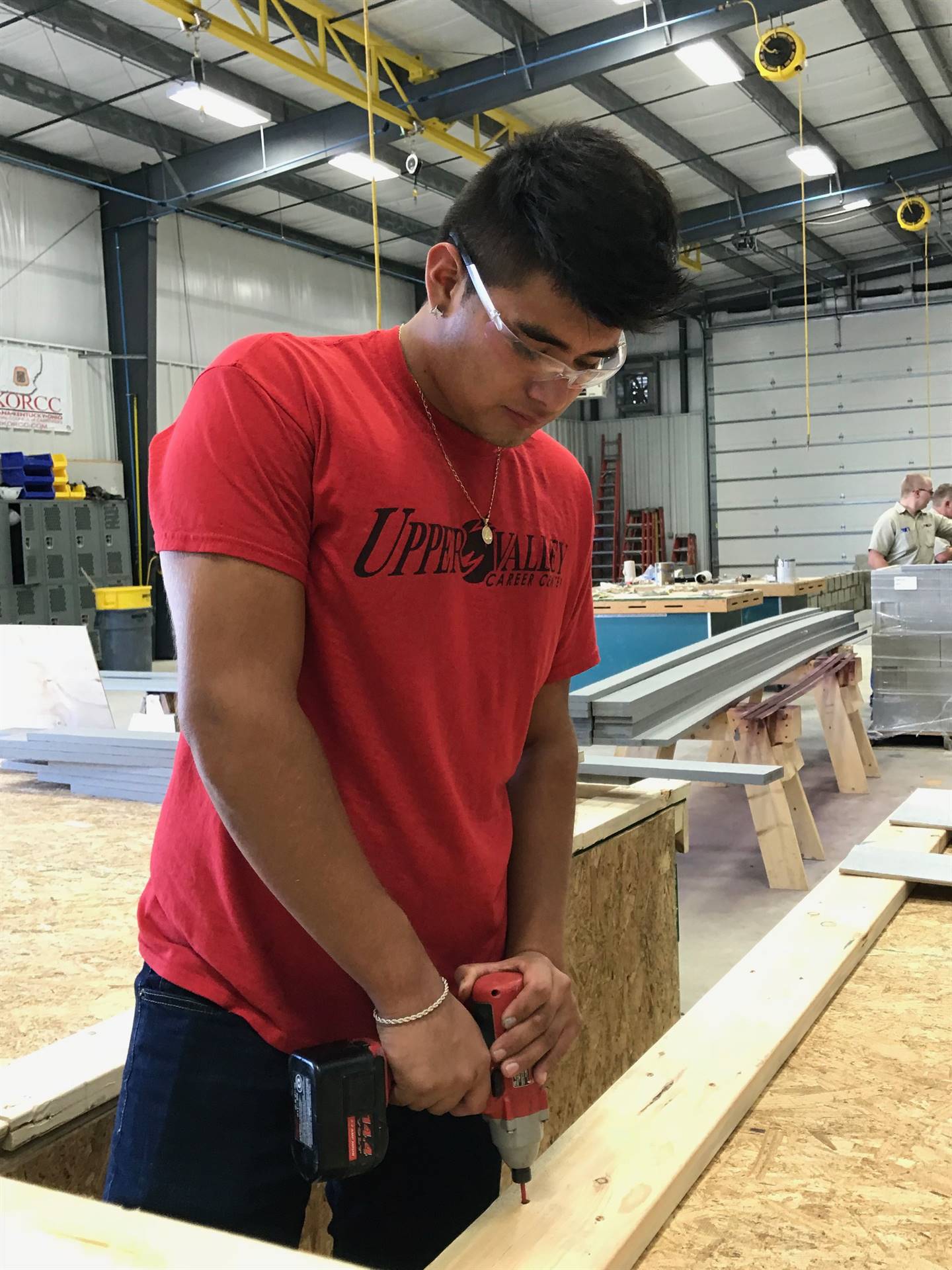 Student drilling nails in wood