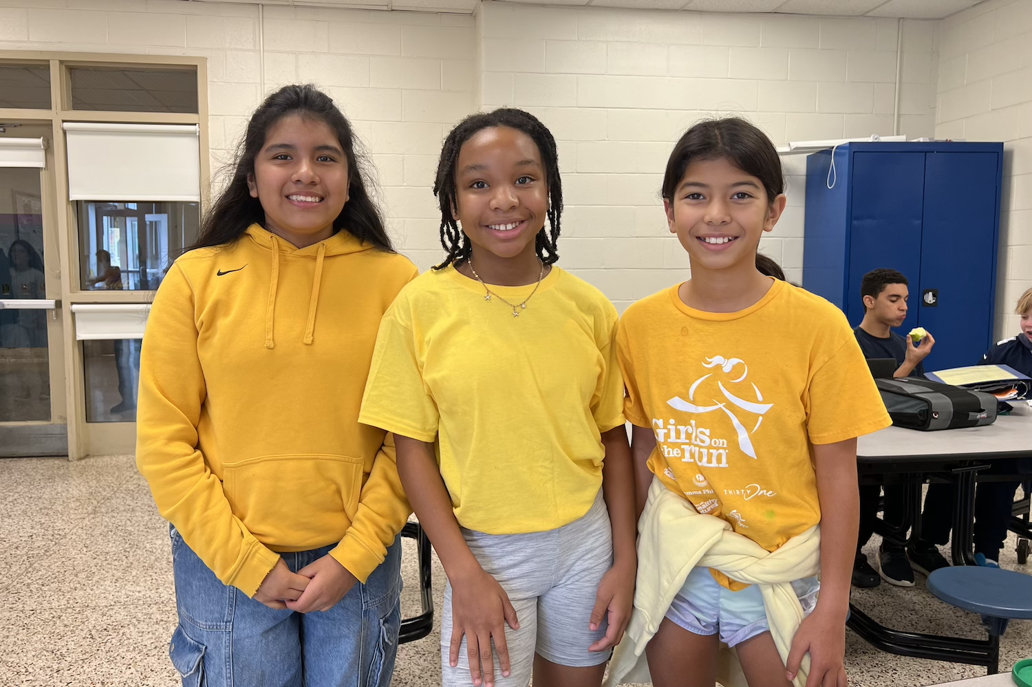 three students wearing gold