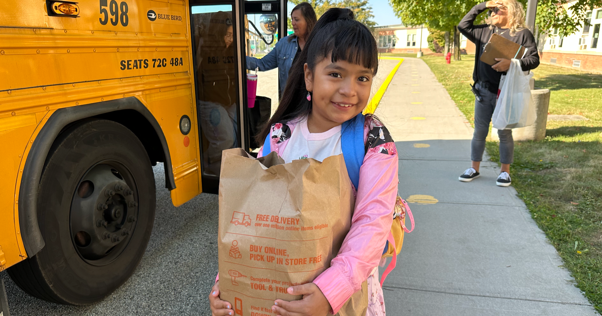 girl holding supplies in grocery bag