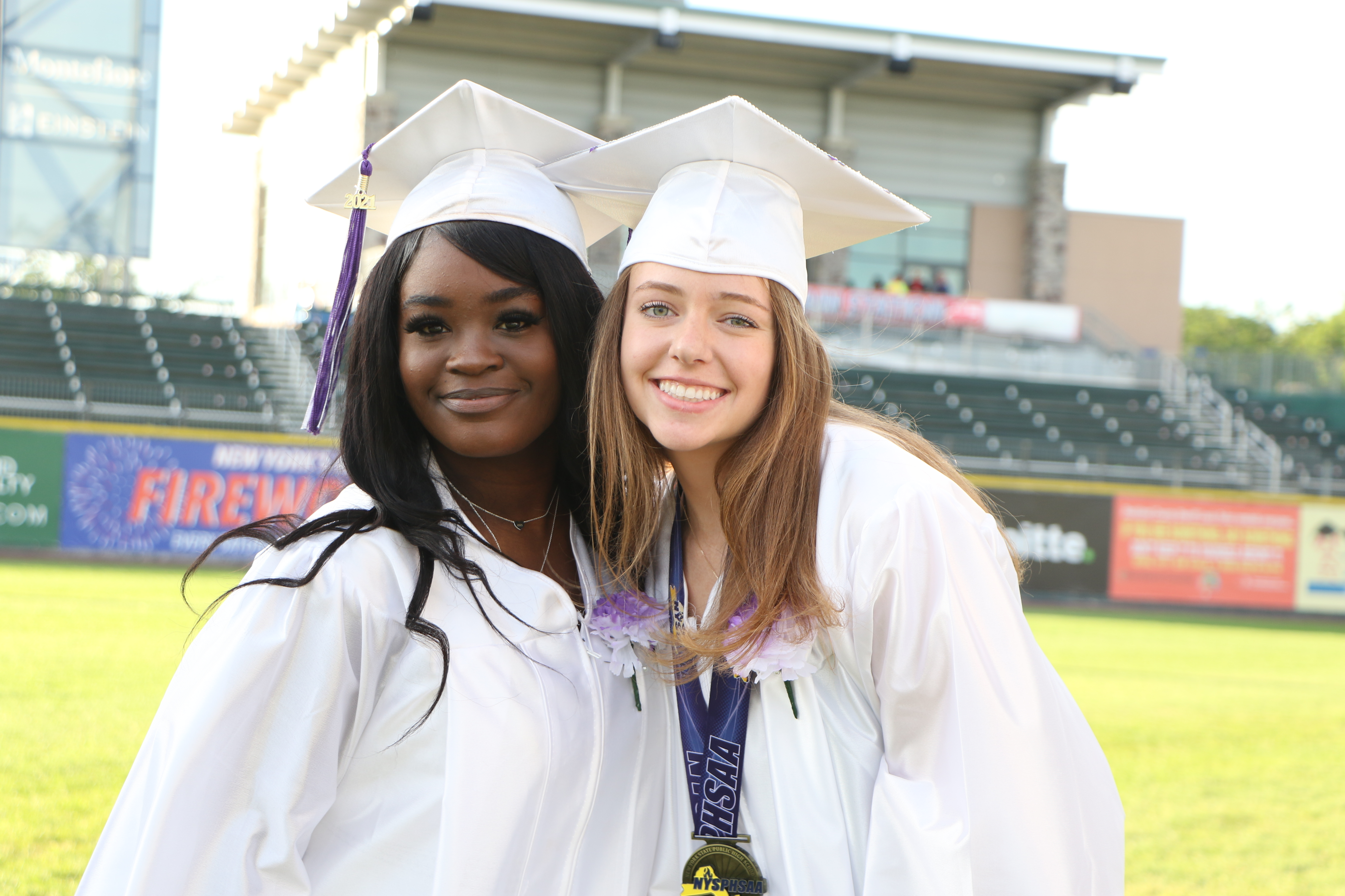 Two graduates smile