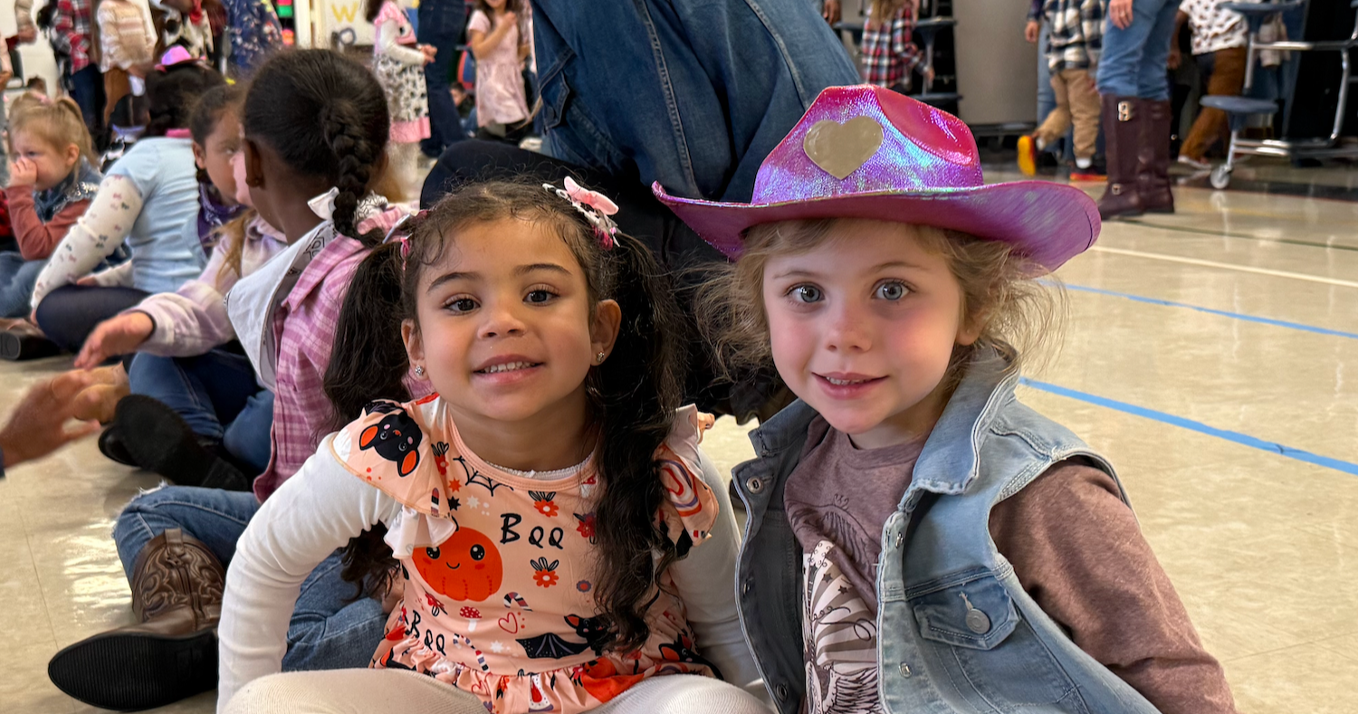 two students wearing cowboy hats and scarves